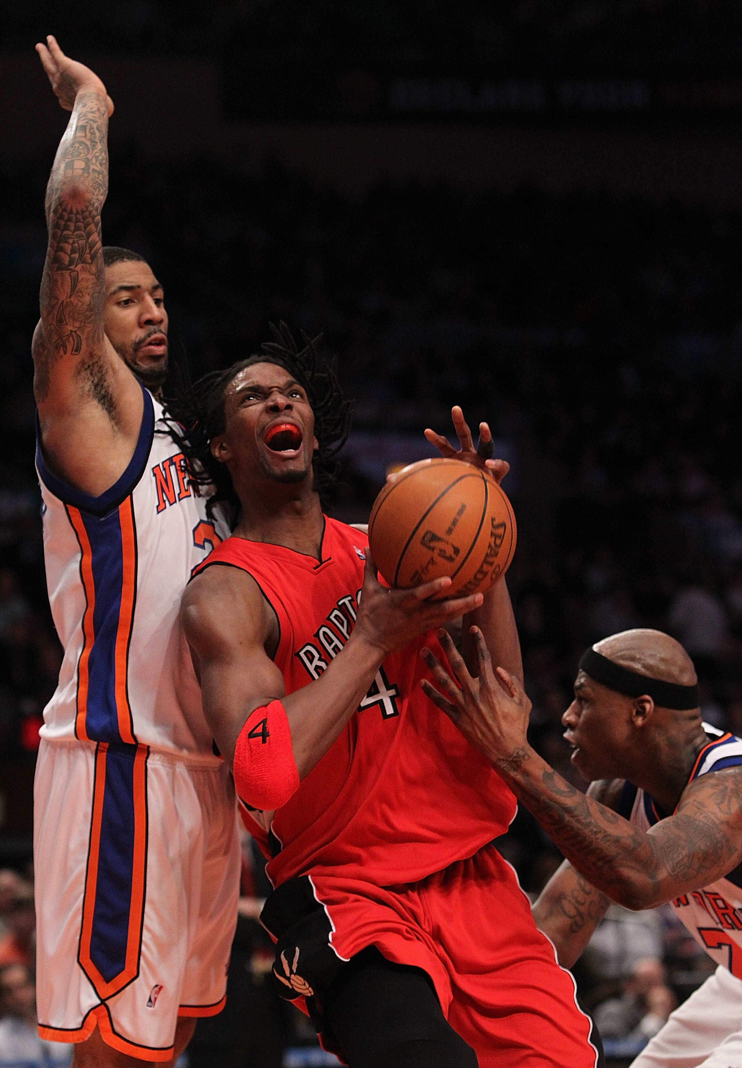 NEW YORK - JANUARY 28: Chris Bosh #4 of the Toronto Raptors drives to the basket between Wilson Chandler #21 and Al Harrington #1 of the New York Knicks at Madison Square Garden on January 28, 2010 in New York, New York. NOTE TO USER: User expressly ackn NEW YORK - JANUARY 28: Chris Bosh #4 of the Toronto Raptors drives to the basket between Wilson Chandler #21 and Al Harrington #1 of the New York Knicks at Madison Square Garden on January 28, 2010 in New York, New York. NOTE TO USER: User expressly ackn