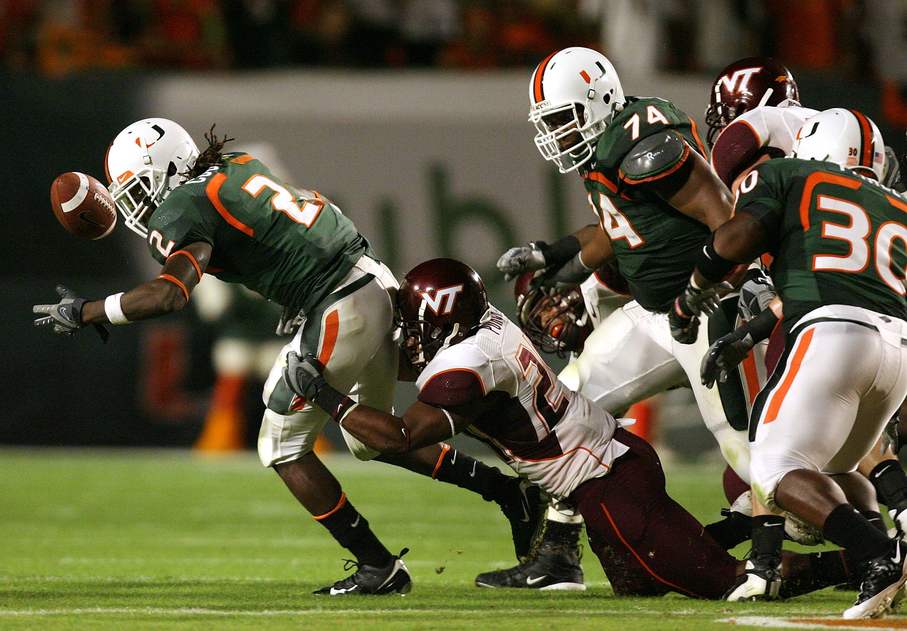 MIAMI - NOVEMBER 13:  Dorian Porch #24 of the Virginia Tech Hokies causes a fumble by running back Craig Cooper #2 of the Miami Hurricanes at Dolphin Stadium on November 13, 2008 in Miami, Florida. Miami defeated Virginia Tech 16-14.  (Photo by Doug Benc/