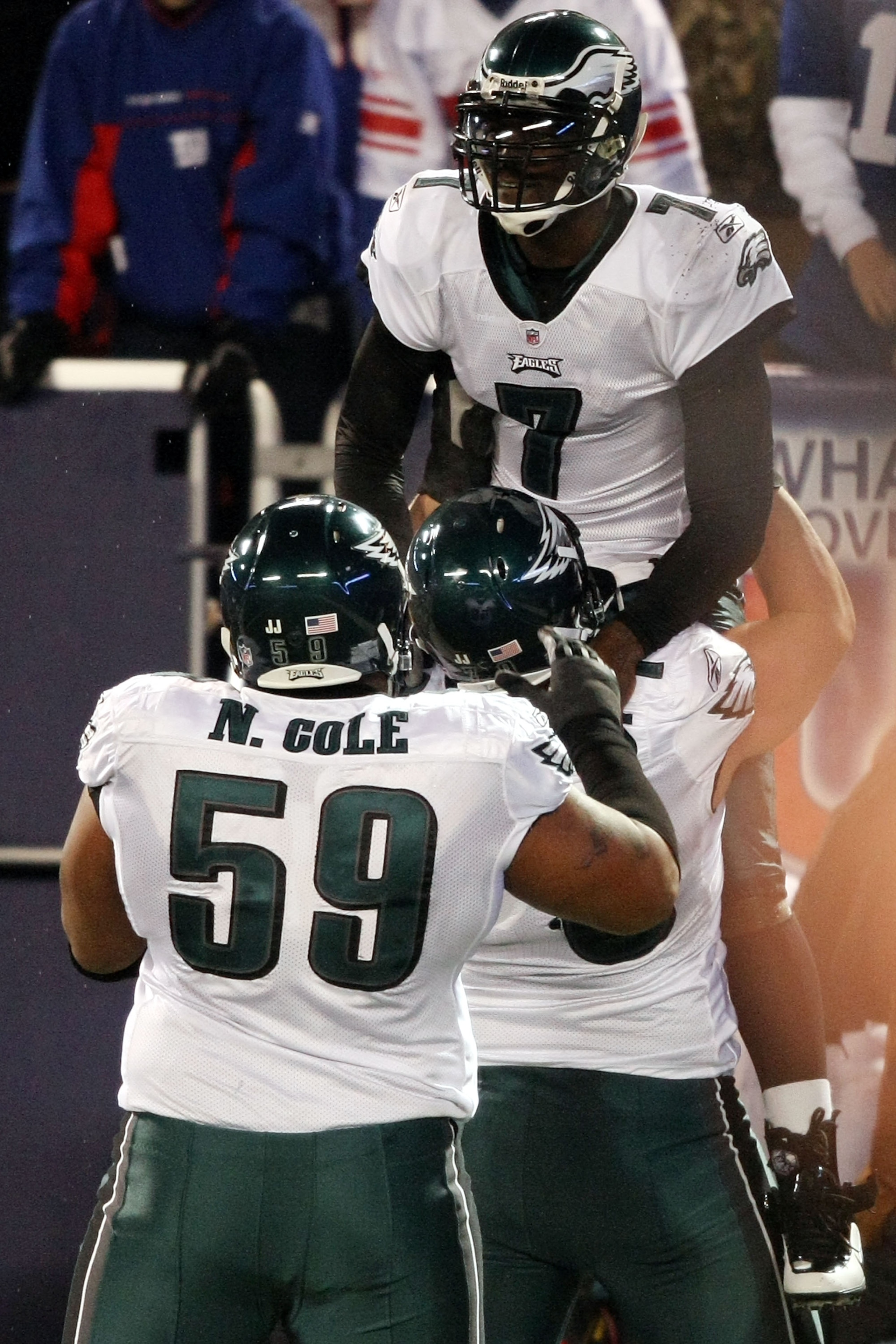 EAST RUTHERFORD, NJ - DECEMBER 13:  Michael Vick #7 of the Philadelphia Eagles celebrates after scoring a touchdown in the second quater with Todd Herremans #79 and Nick Cole #59 against the New York Giants at Giants Stadium on December 13, 2009 in East R