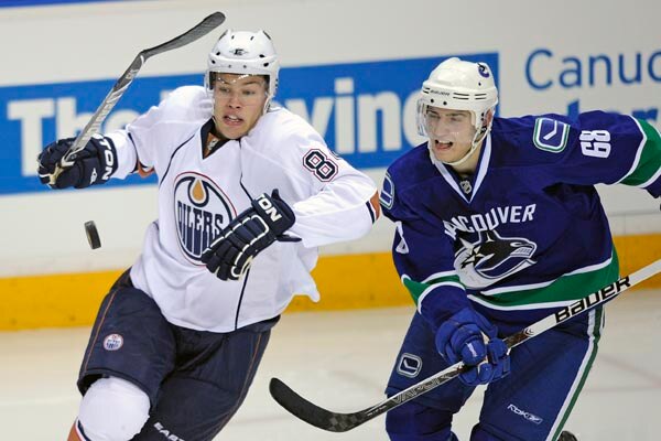 Edmontons's Talylor Hall and Canucks Chris Tanev