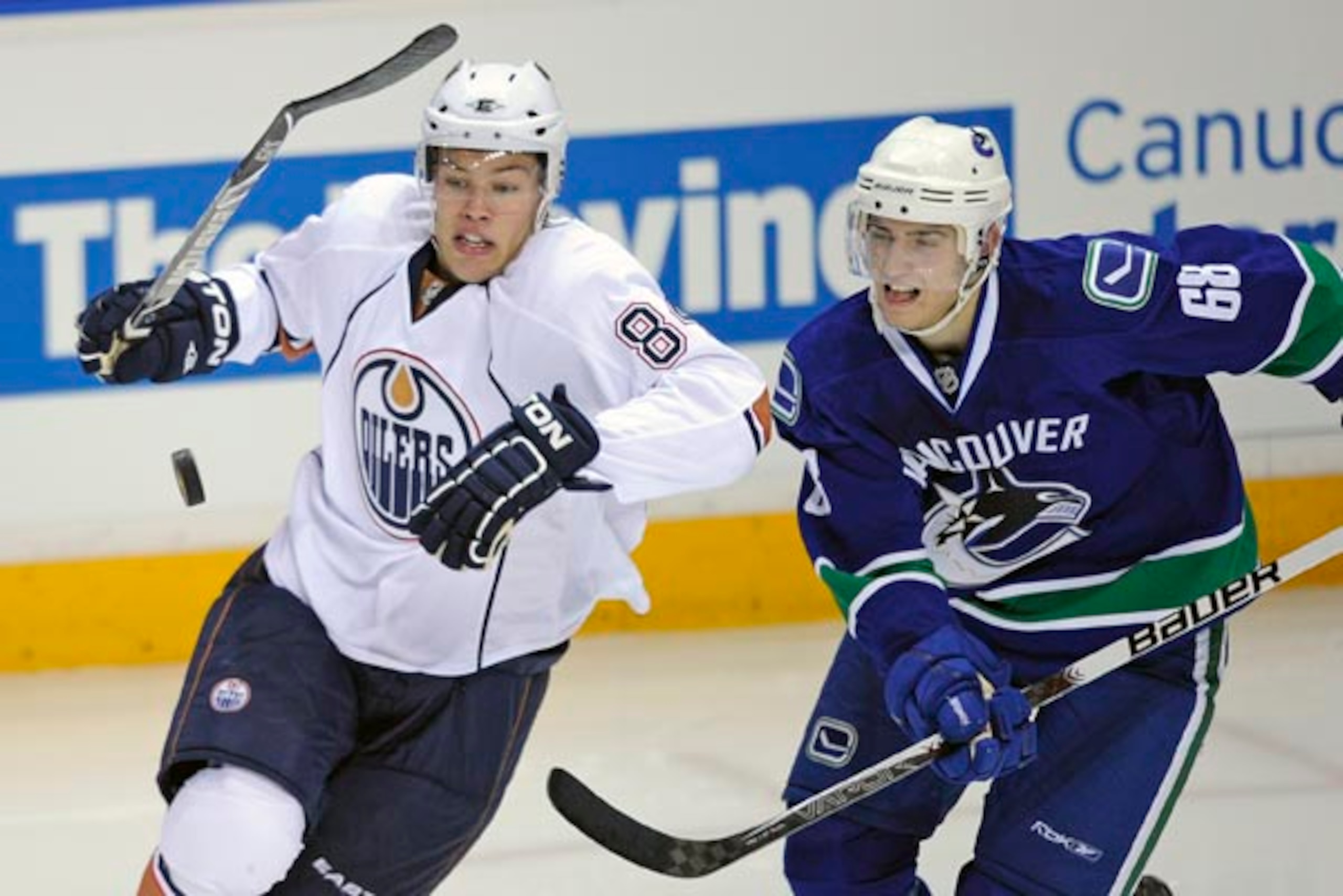 Edmontons's Talylor Hall and Canucks Chris Tanev