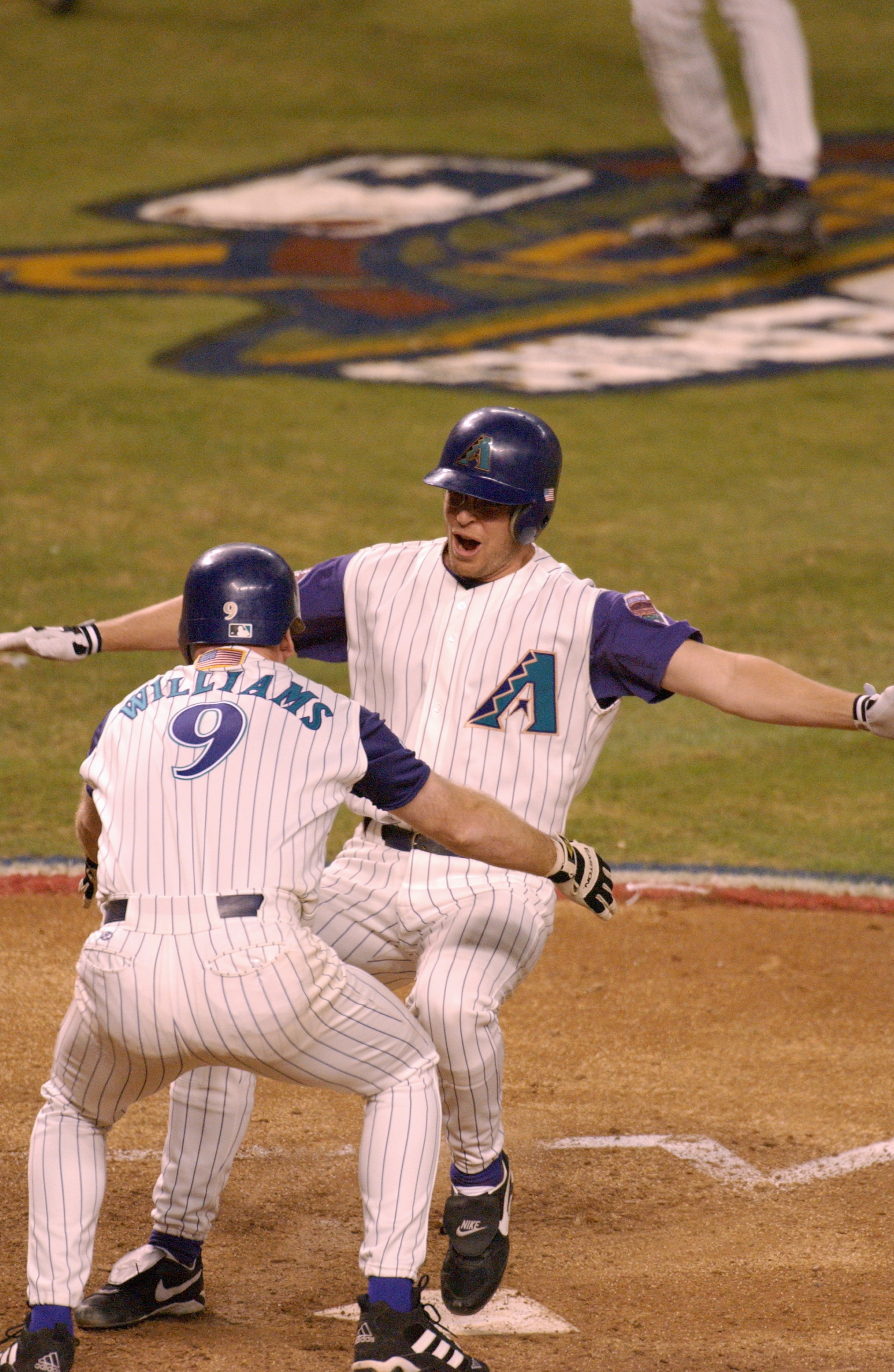 4 Nov 2001: Jay Bell #48 of the Arizona Diamondbacks is met at home plate by teammate Matt Williams #9 as he scores the winning run in the ninth inning against the New York Yankees during game seven of the Major League Baseball World Series at Bank One Ba 4 Nov 2001: Jay Bell #48 of the Arizona Diamondbacks is met at home plate by teammate Matt Williams #9 as he scores the winning run in the ninth inning against the New York Yankees during game seven of the Major League Baseball World Series at Bank One Ba