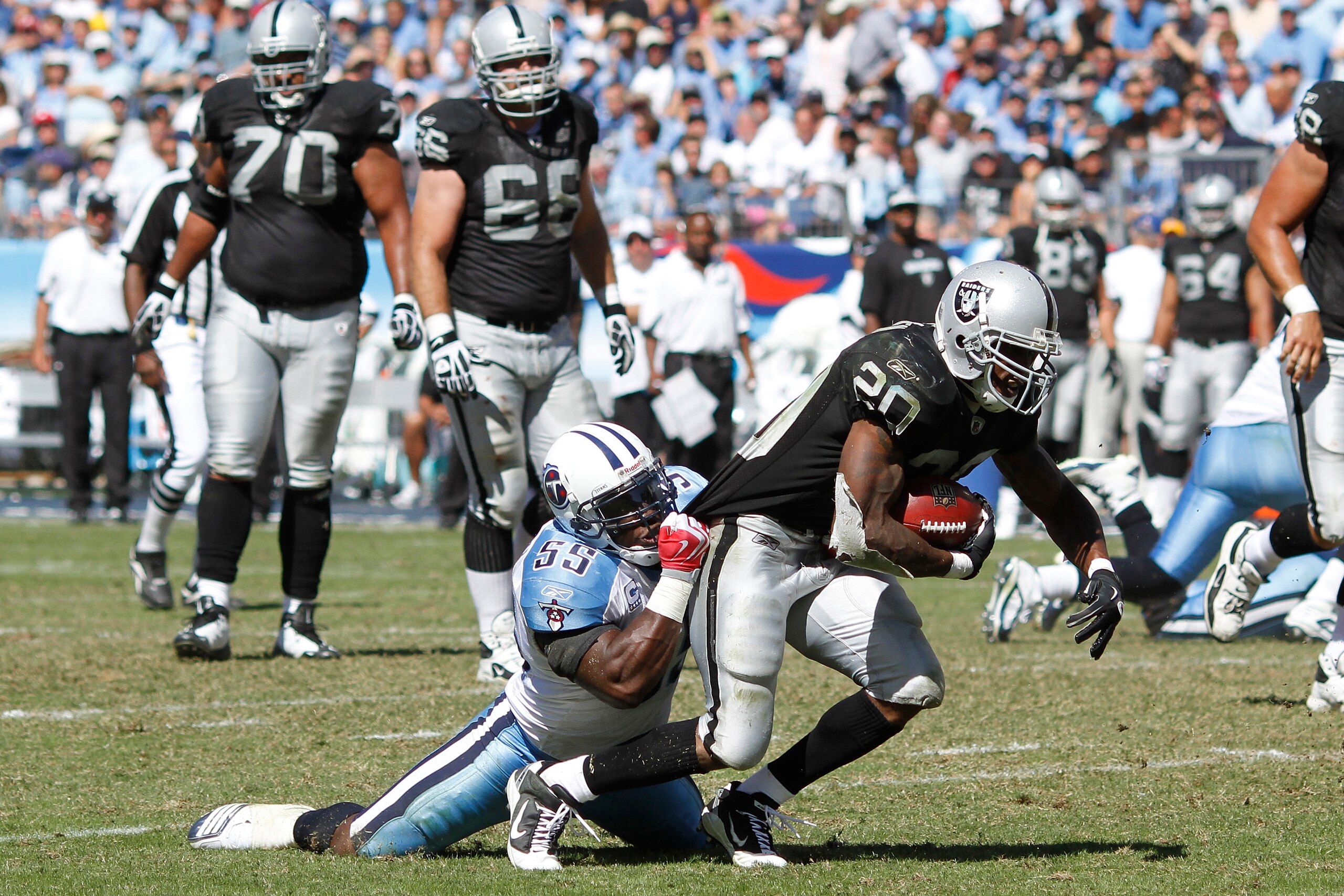 NASHVILLE - SEPTEMBER 12: Stephen Tulloch #55 of the Tennessee Titans tackles Darren McFadden #20 of the Oakland Raiders during the NFL season opener at LP Field on September 12, 2010 in Nashville, Tennessee. The Titans defeated the Raiders 38-13. (Photo 