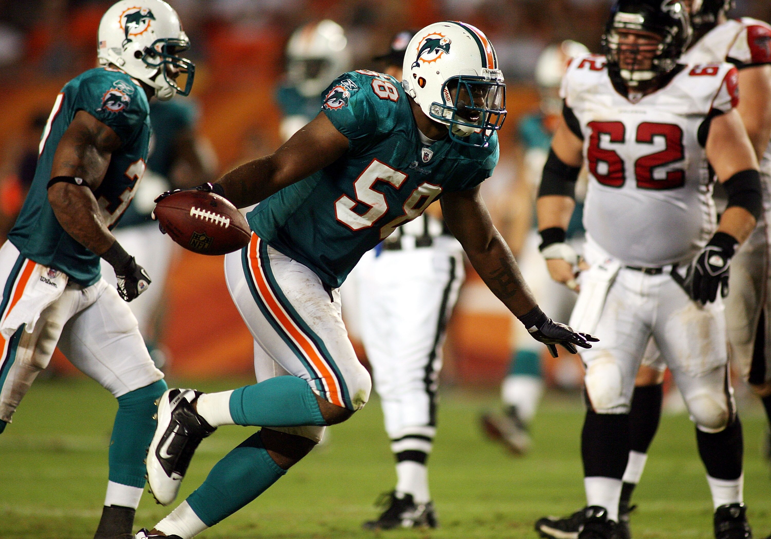 MIAMI - AUGUST 27: Linebacker Karlos Dansby #58 of the Miami Dolphins celebrates his fumble recovery against the Atlanta Falcons during preseason action at Sun Life Stadium on August 27, 2010 in Miami, Florida.  (Photo by Marc Serota/Getty Images)
