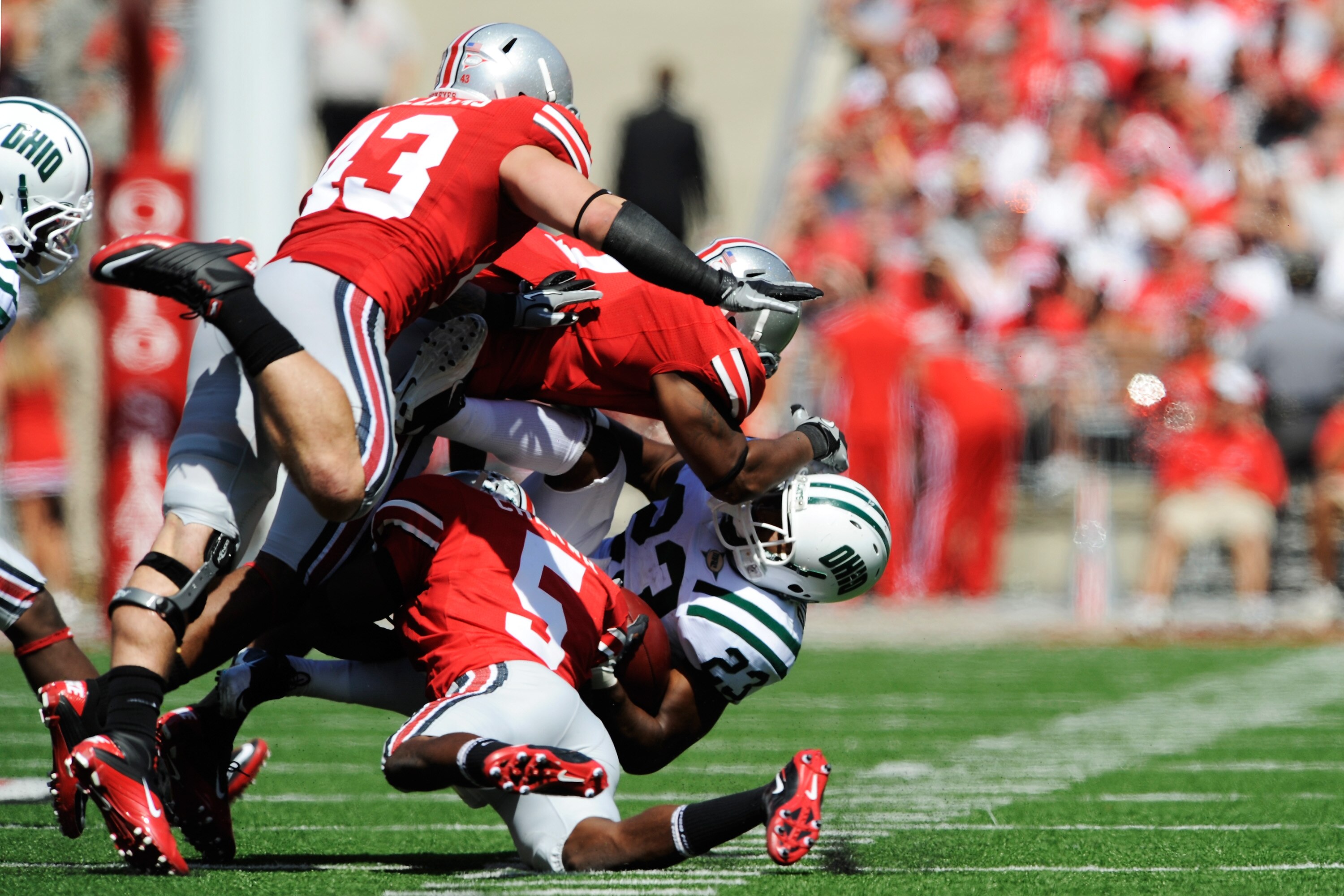 COLUMBUS, OH - SEPTEMBER 18:  Dallas Brown #23 of the Ohio Bobcats is gang tackled by Chimdi Chekwa #5, Jermale Hines #7 and Nathan Williams #43, all of the Ohio State Buckeyes at Ohio Stadium on September 18, 2010 in Columbus, Ohio.  (Photo by Jamie Saba