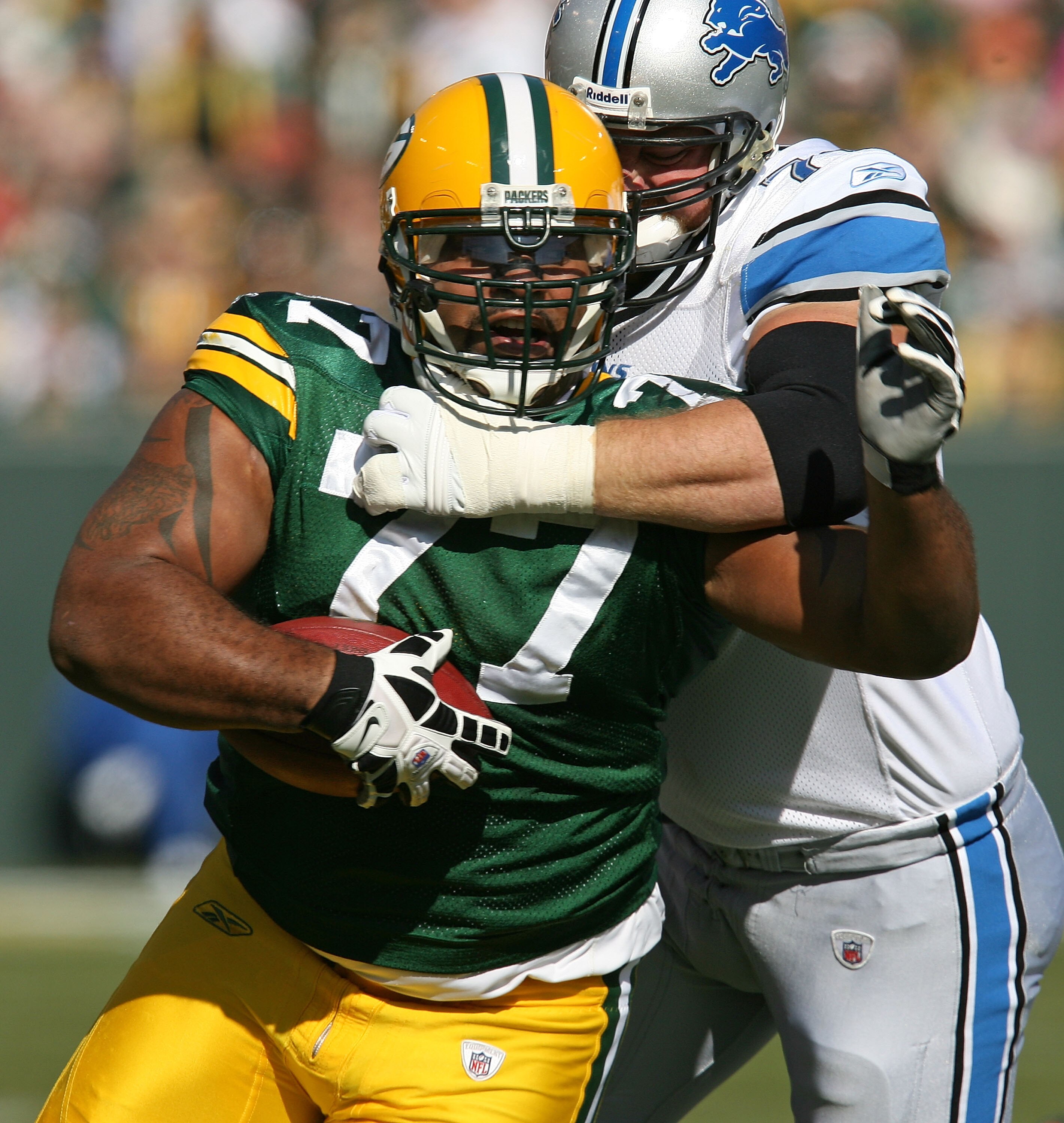 GREEN BAY, WI - OCTOBER 18: Cullen Jenkins #77 of the Green Bay Packers tries to run after intercepting a pass as Jeff Backus #76 of Detroit Lions drags him down at Lambeau Field on October 18, 2009 in Green Bay, Wisconsin. (Photo by Jonathan Daniel/Getty
