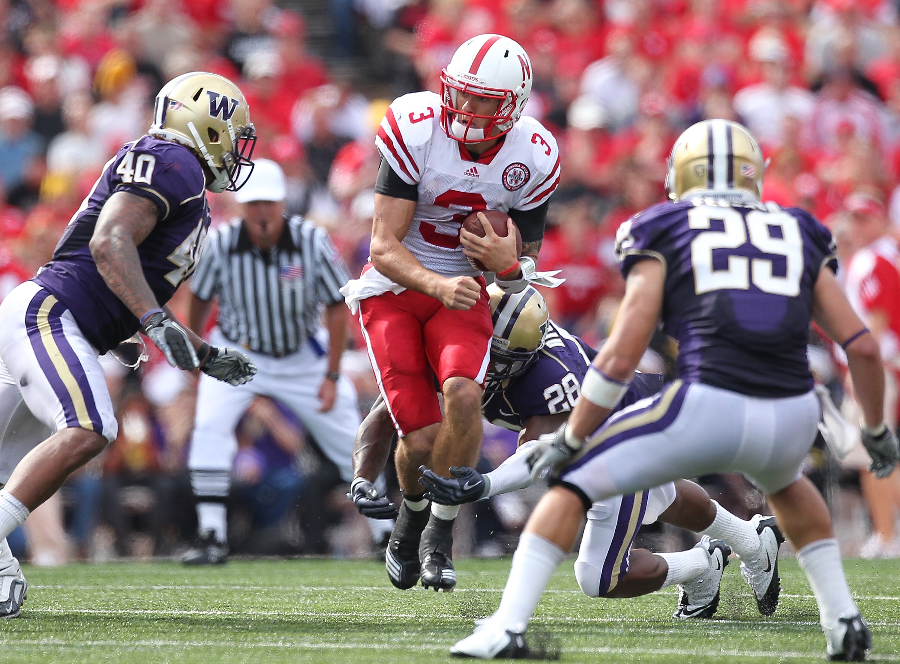 SEATTLE - SEPTEMBER 18:  Quarterback Taylor Martinez #3 of the Nebraska Cornhuskers rushes against Quinton Richardson #28 of the Washington Huskies on September 18, 2010 at Husky Stadium in Seattle, Washington. The Cornhuskers defeated the Huskies 56-21.(