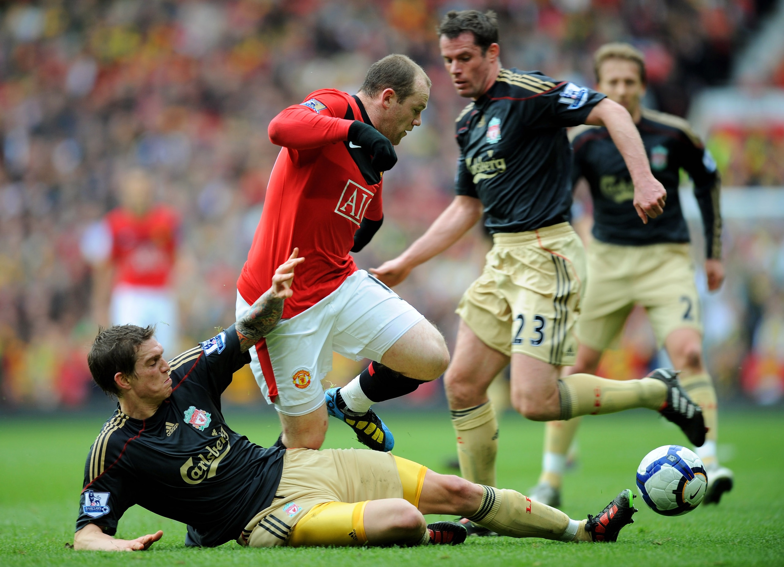 MANCHESTER, ENGLAND - MARCH 21: Wayne Rooney (C) of Manchester United is challenged by Daniel Agger (L) and Jamie Carragher of Liverpool  during the Barclays Premier League match between Manchester United and Liverpool at Old Trafford on March 21, 2010 in