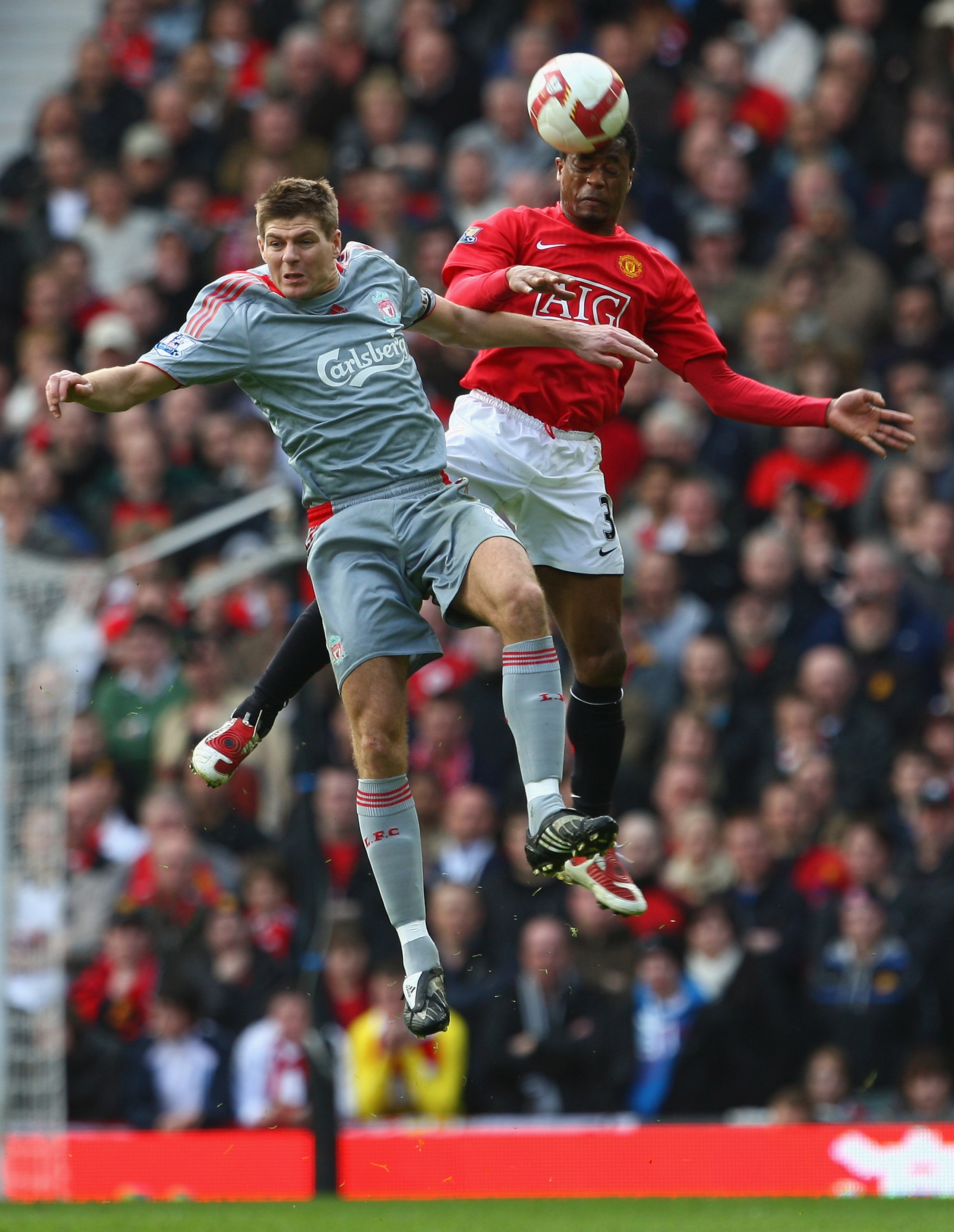 MANCHESTER, UNITED KINGDOM - MARCH 14:  Steven Gerrard of Liverpool goes up for a header with Patrice Evra of Manchester United during the Barclays Premier League match between Manchester United and Liverpool at Old Trafford on March 14, 2009 in Mancheste