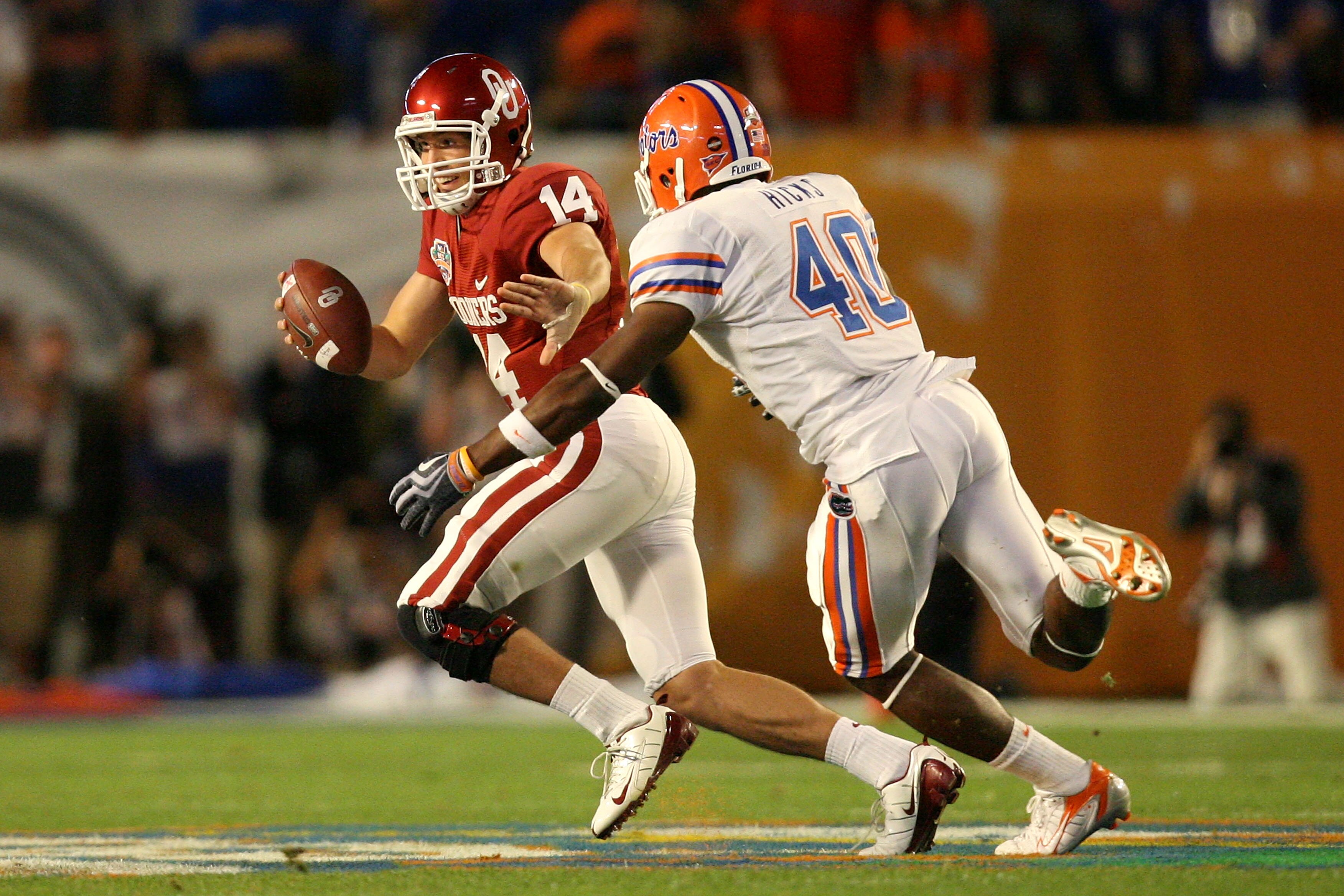 MIAMI - JANUARY 08:  Sam Bradford #14 of the Oklahoma Sooners attempts to escape the pass rush from Brandon Hicks #40 of the Florida Gators during the FedEx BCS National Championship game at Dolphin Stadium on January 8, 2009 in Miami, Florida.  (Photo by