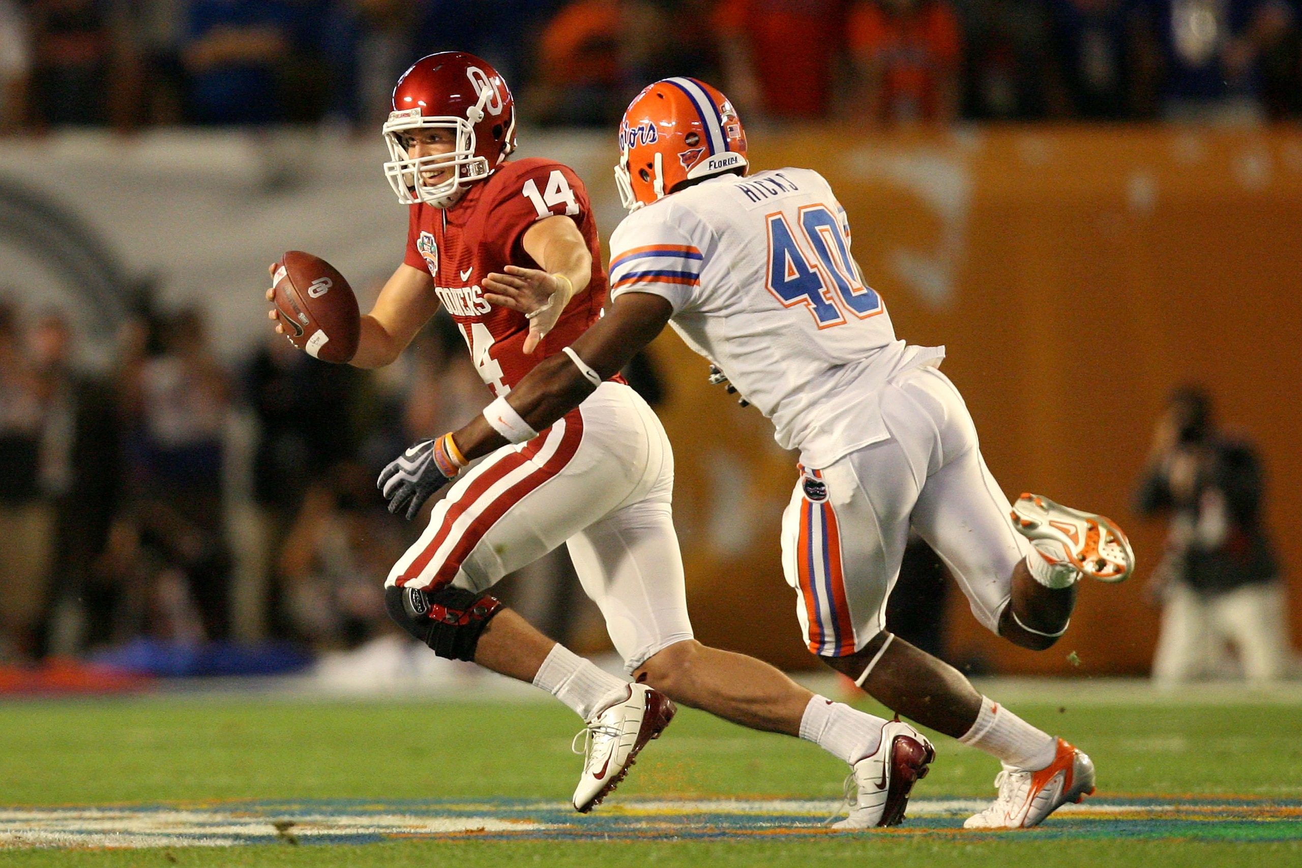 MIAMI - JANUARY 08:  Sam Bradford #14 of the Oklahoma Sooners attempts to escape the pass rush from Brandon Hicks #40 of the Florida Gators during the FedEx BCS National Championship game at Dolphin Stadium on January 8, 2009 in Miami, Florida.  (Photo by