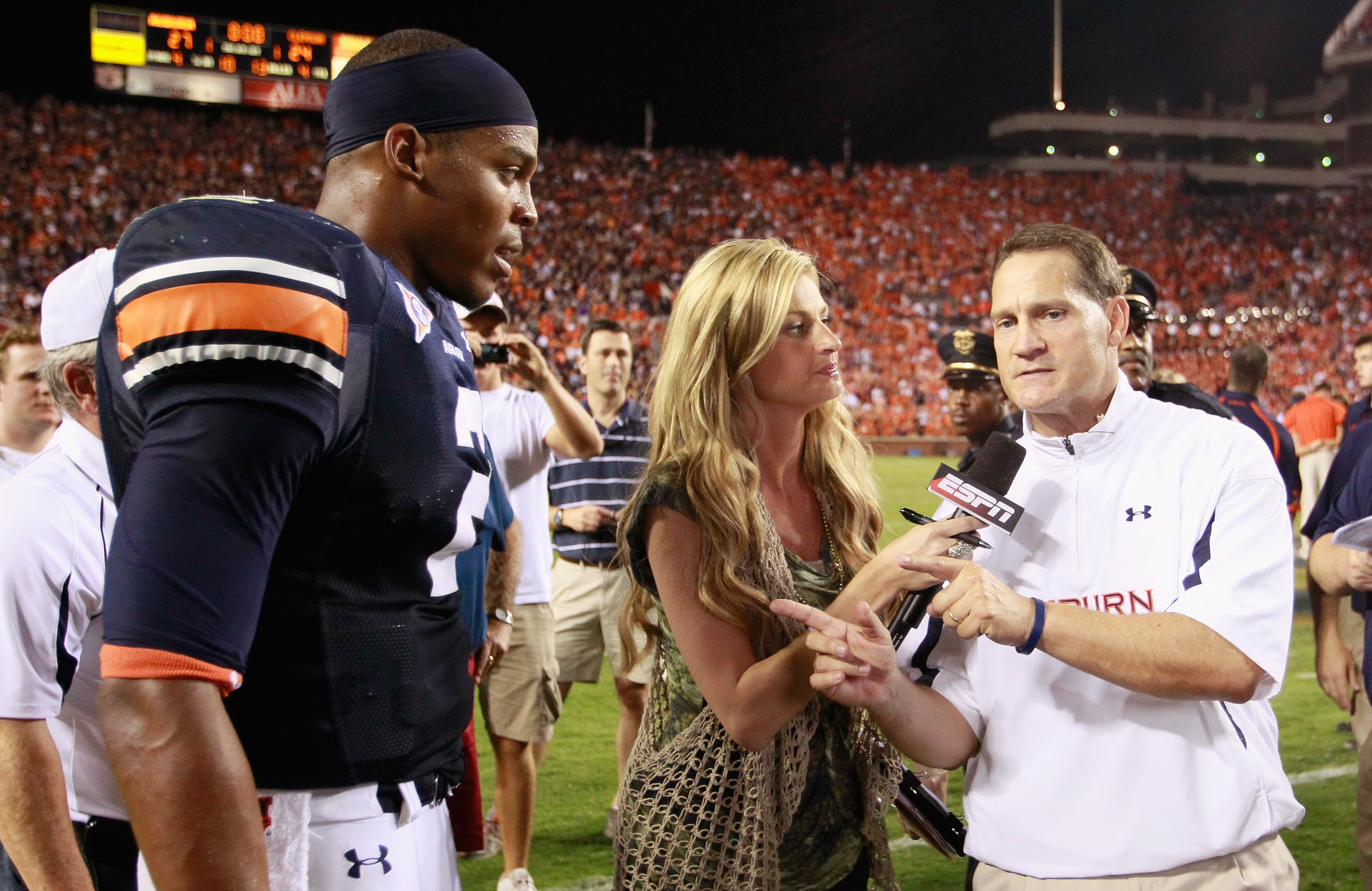 AUBURN, AL - SEPTEMBER 18:  Quarterback Cameron Newton #2 of the Auburn Tigers waits as Erin Andrews finishes her interview with head coach Gene Chizik after their 27-24 overtime win over the Clemson Tigers at Jordan-Hare Stadium on September 18, 2010 in 