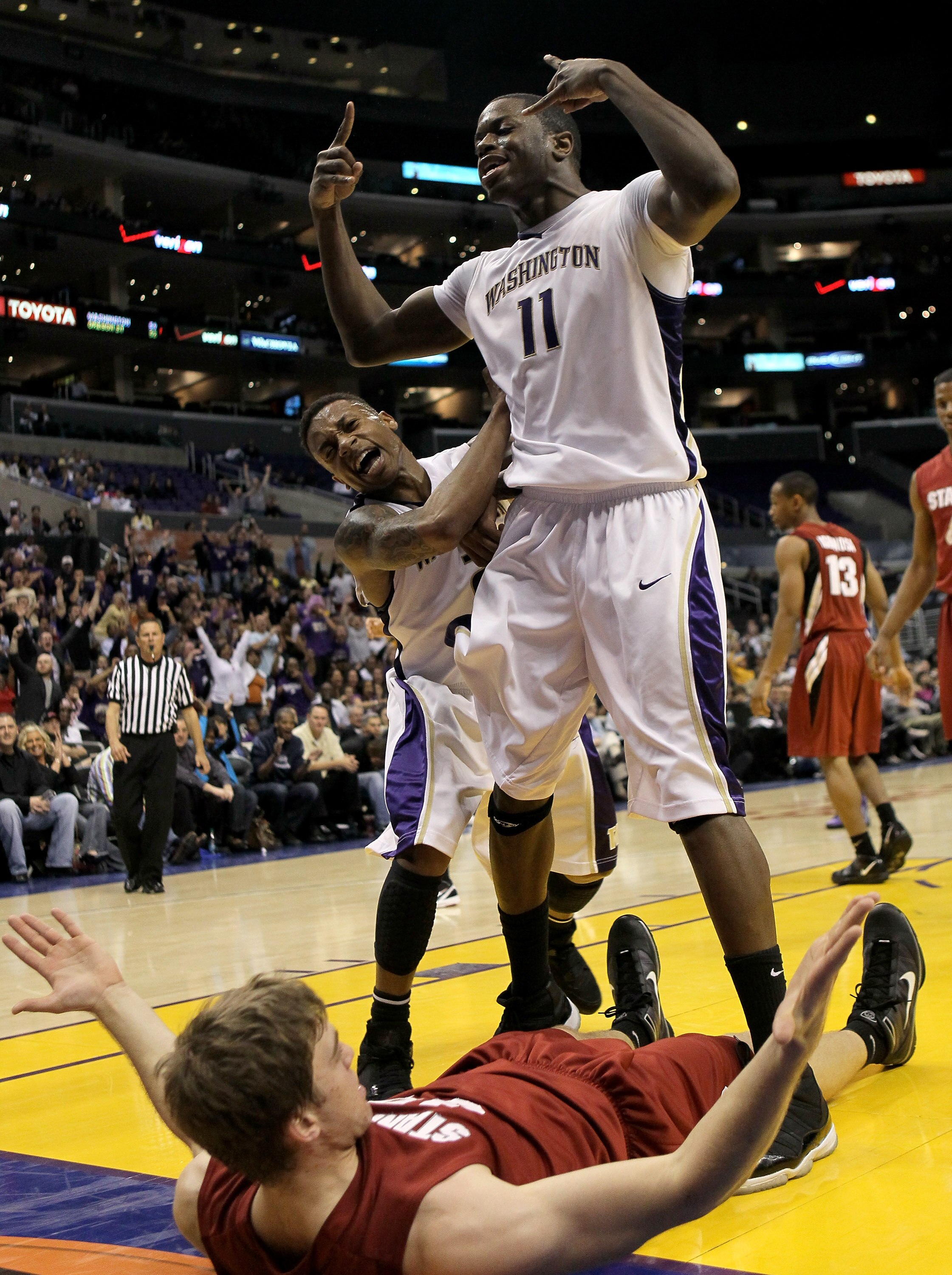 LOS ANGELES, CA - MARCH 12:  Matthew Bryan-Amaning #11 and Isaiah Thomas #3 of the Washington Huskies celebrate Bryan-Amaning's dunk over Andrew Zimmermann #34 of the Stanford Cardinal during the semifinals of the Pac-10 Basketball Tournament at Staples C