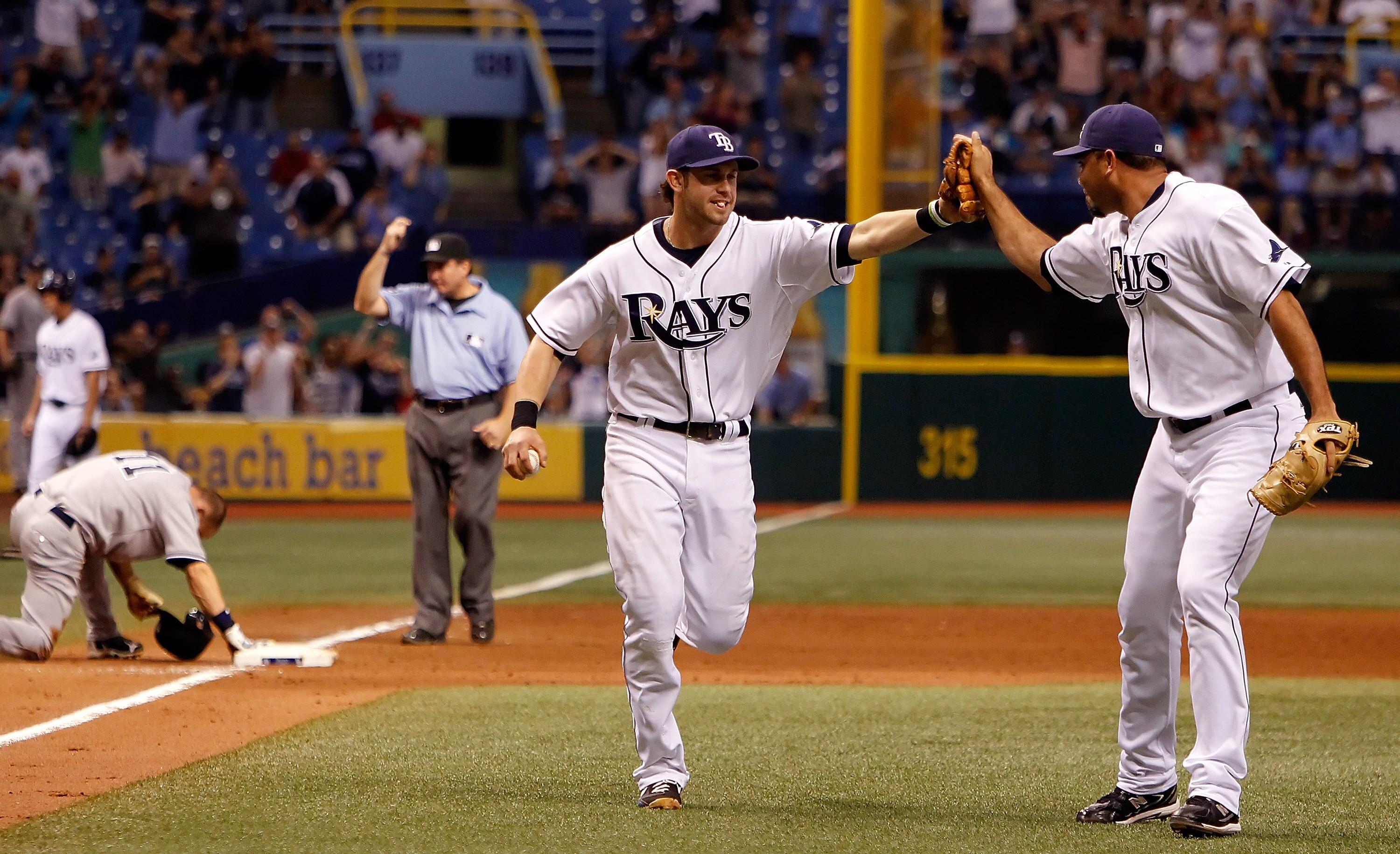 ST. PETERSBURG - SEPTEMBER 13:  Infielder Evan Longoria #3 of the Tampa Bay Rays is congratulated by pitcher Joaquin Benoit #53 after picking off pinch runner Brett Gardner #11 of the New York Yankees during the game at Tropicana Field on September 13, 20