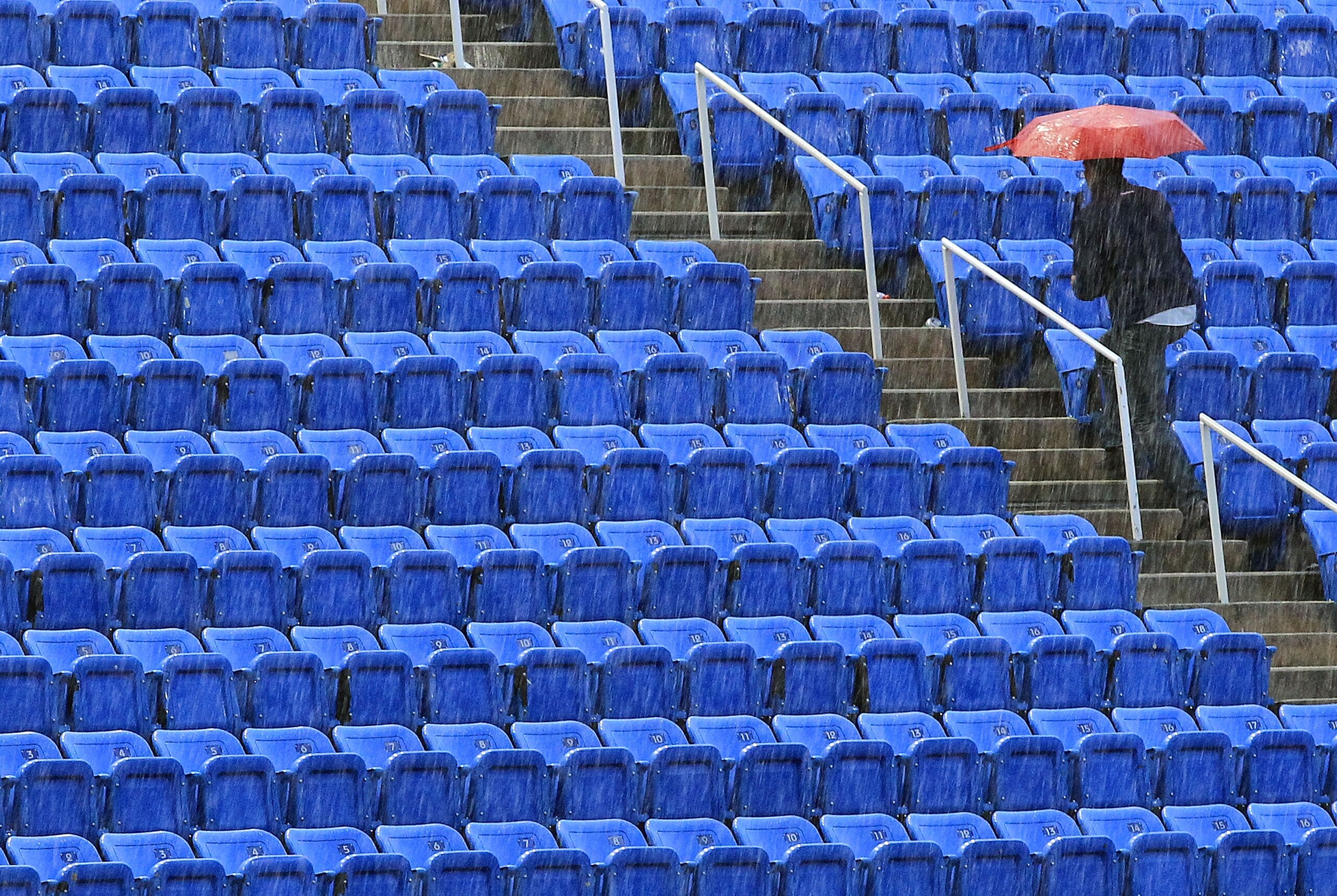 NEW YORK - SEPTEMBER 13: A fan walks up the stairs under an umbrella as play is suspended due to rain during the men's singles final match between Novak Djokovic of Serbia and Rafael Nadal of Spain on day fifteen of the 2010 U.S. Open at the USTA Billie NEW YORK - SEPTEMBER 13: A fan walks up the stairs under an umbrella as play is suspended due to rain during the men's singles final match between Novak Djokovic of Serbia and Rafael Nadal of Spain on day fifteen of the 2010 U.S. Open at the USTA Billie
