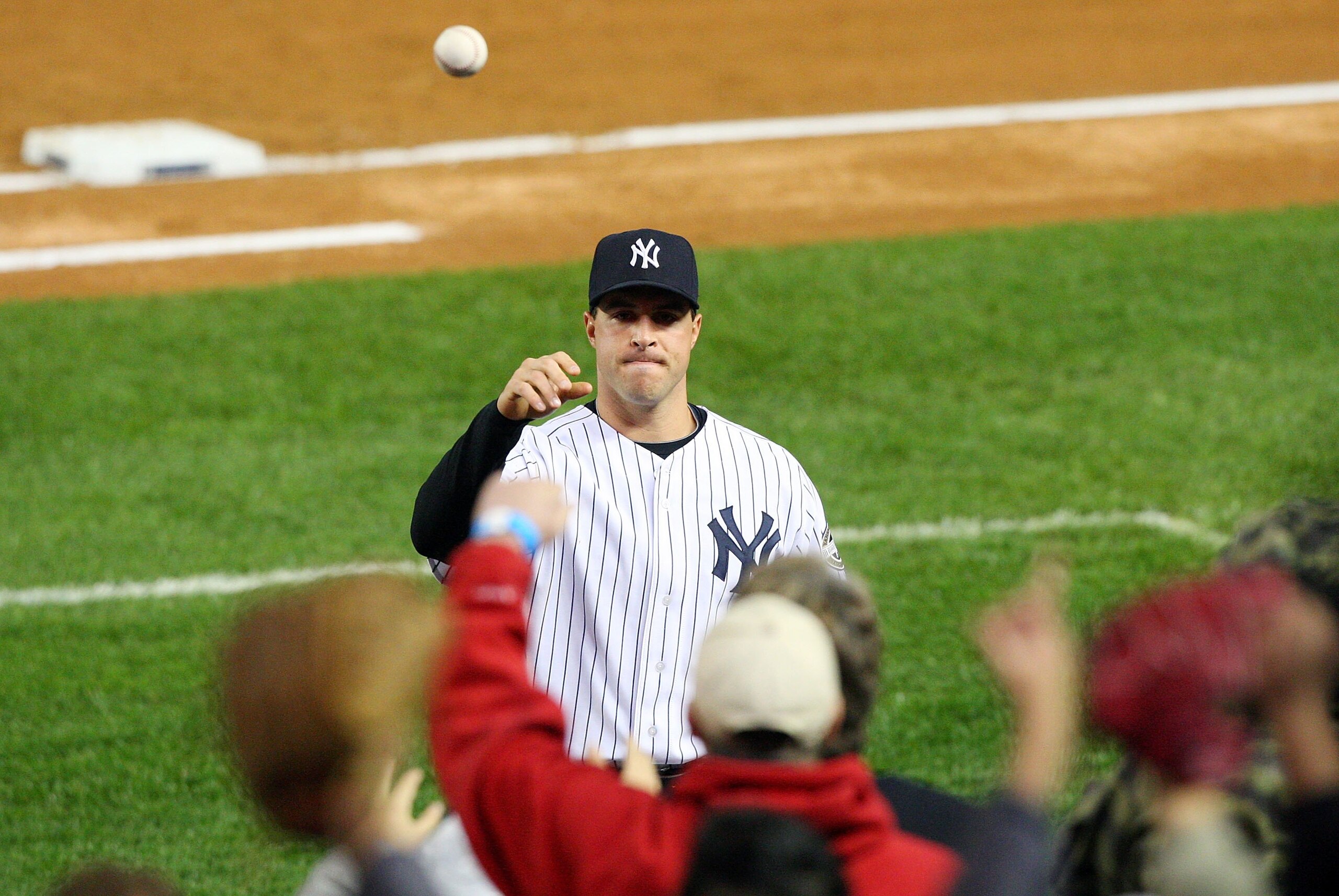 NEW YORK - MAY 04:  Mark Teixiera #25 of the New York Yankees throws a ball to a fan prior to playing the Boston Red Sox on May 4, 2009 at Yankee Stadium in the Bronx borough of New York City.  (Photo by Jim McIsaac/Getty Images)