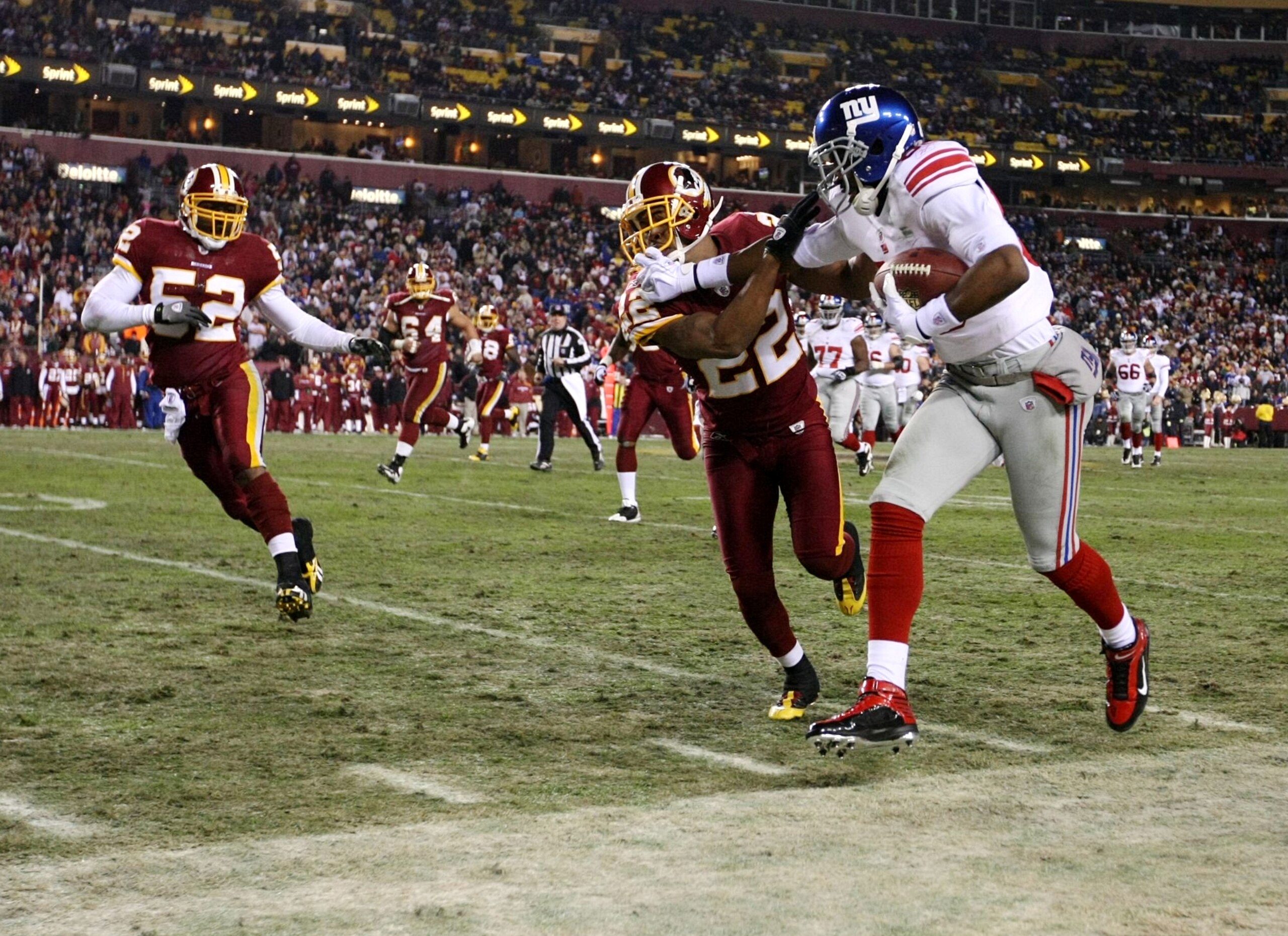 LANDOVER, MD - DECEMBER 21:  Hakeem Nicks #88 of the New York Giants stiff-arms Carlos Rogers #22 of the Washington Redskins after a 21-yard gain on a first quarter catch at FedEx Field on December 21, 2009 in Landover, Maryland. (Photo by Al Bello/Getty