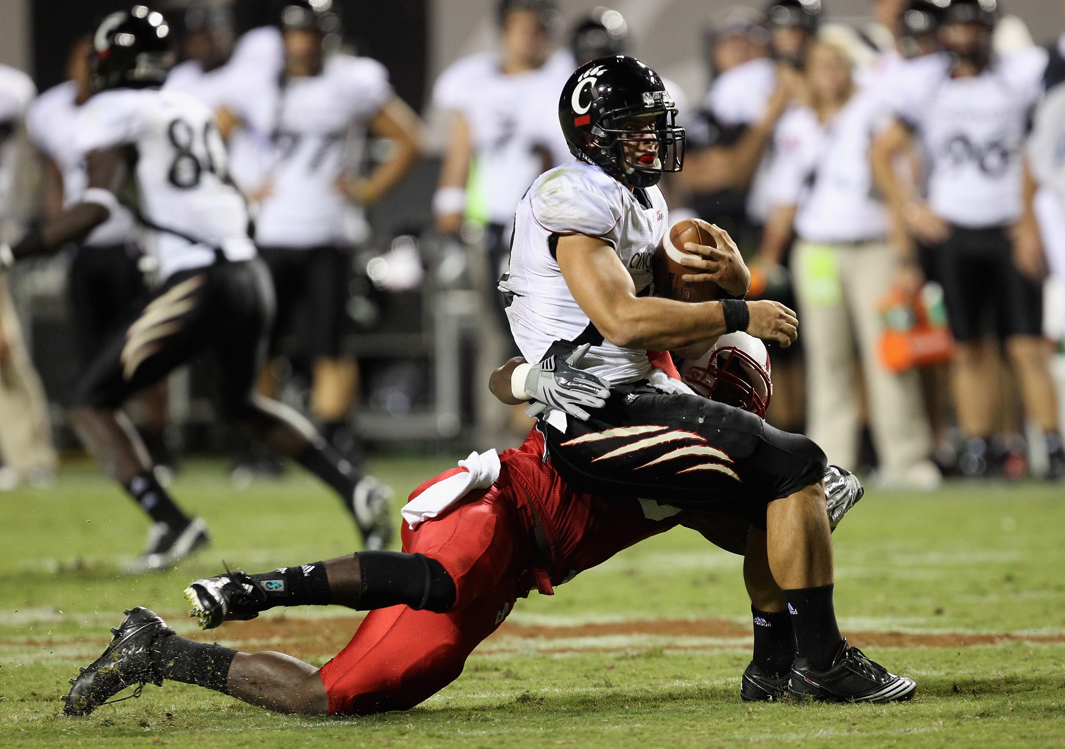 RALEIGH, NC - SEPTEMBER 16:  Zack Collaros #12 of the Cincinnati Bearcats is sacked by Terrell Manning #35 of the North Carolina State Wolfpack during their game at Carter-Finley Stadium on September 16, 2010 in Raleigh, North Carolina.  (Photo by Streete