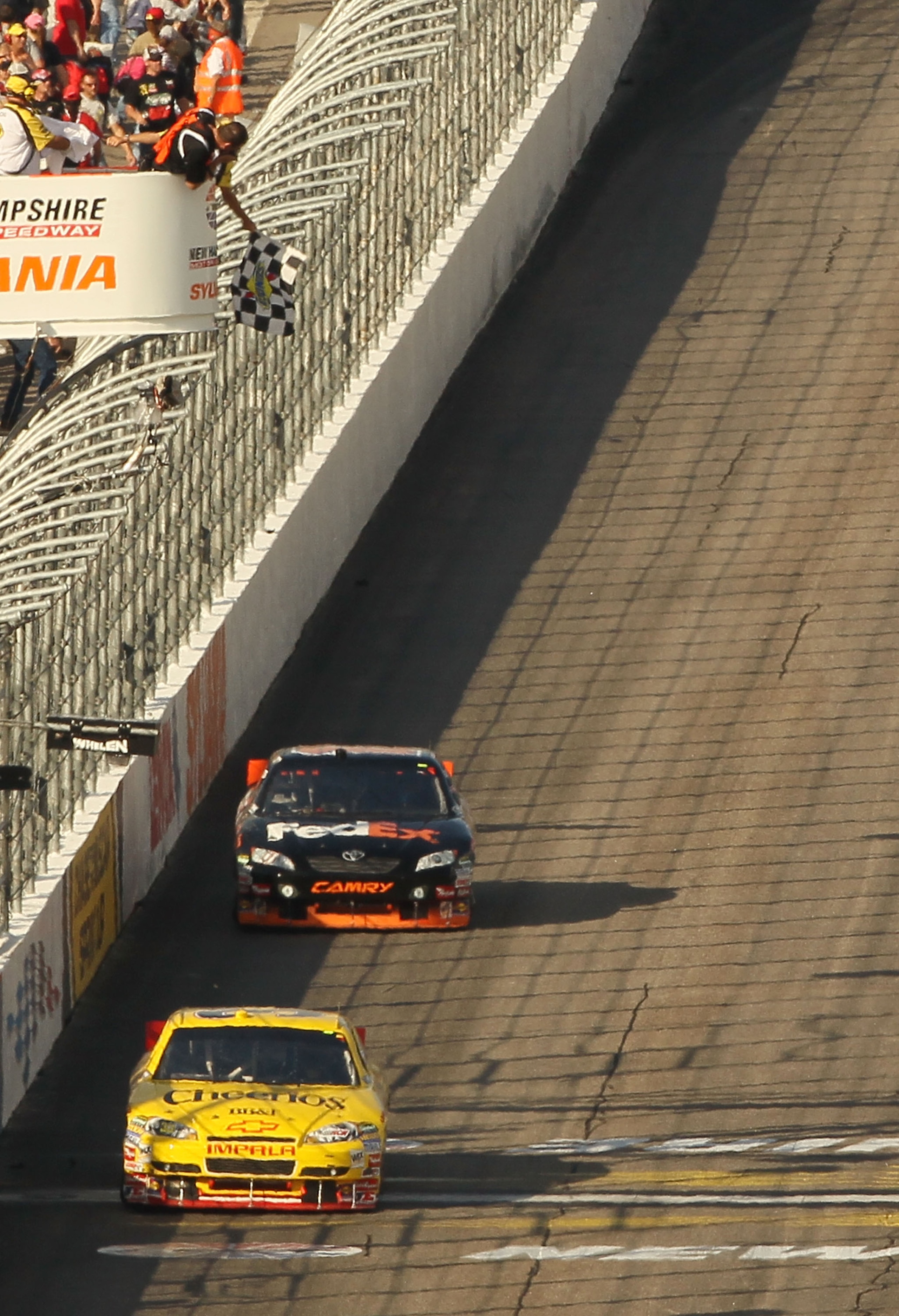 LOUDON, NH - SEPTEMBER 19: Clint Bowyer, driver of the #33 Cheerios / Hamburger Helper Chevrolet, crosses the start / finish line to take the checkered flag and win ahead of Denny Hamlin, driver of the #11 FedEx Small Business Toyota, during the NASCAR S LOUDON, NH - SEPTEMBER 19: Clint Bowyer, driver of the #33 Cheerios / Hamburger Helper Chevrolet, crosses the start / finish line to take the checkered flag and win ahead of Denny Hamlin, driver of the #11 FedEx Small Business Toyota, during the NASCAR S