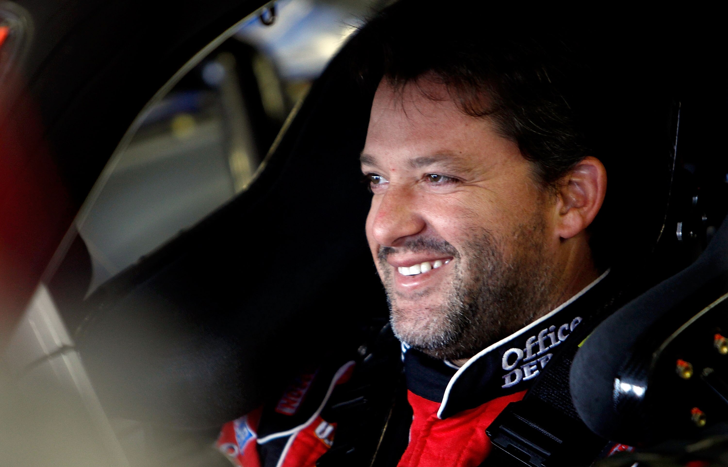 LOUDON, NH - SEPTEMBER 18:  Tony Stewart, driver of the #14 Office Depot / Old Spice Chevrolet, smiles as he sits in his car during practice for the NASCAR Sprint Cup Series Sylvania 300 at New Hampshire Motor Speedway on September 18, 2010 in Loudon, New