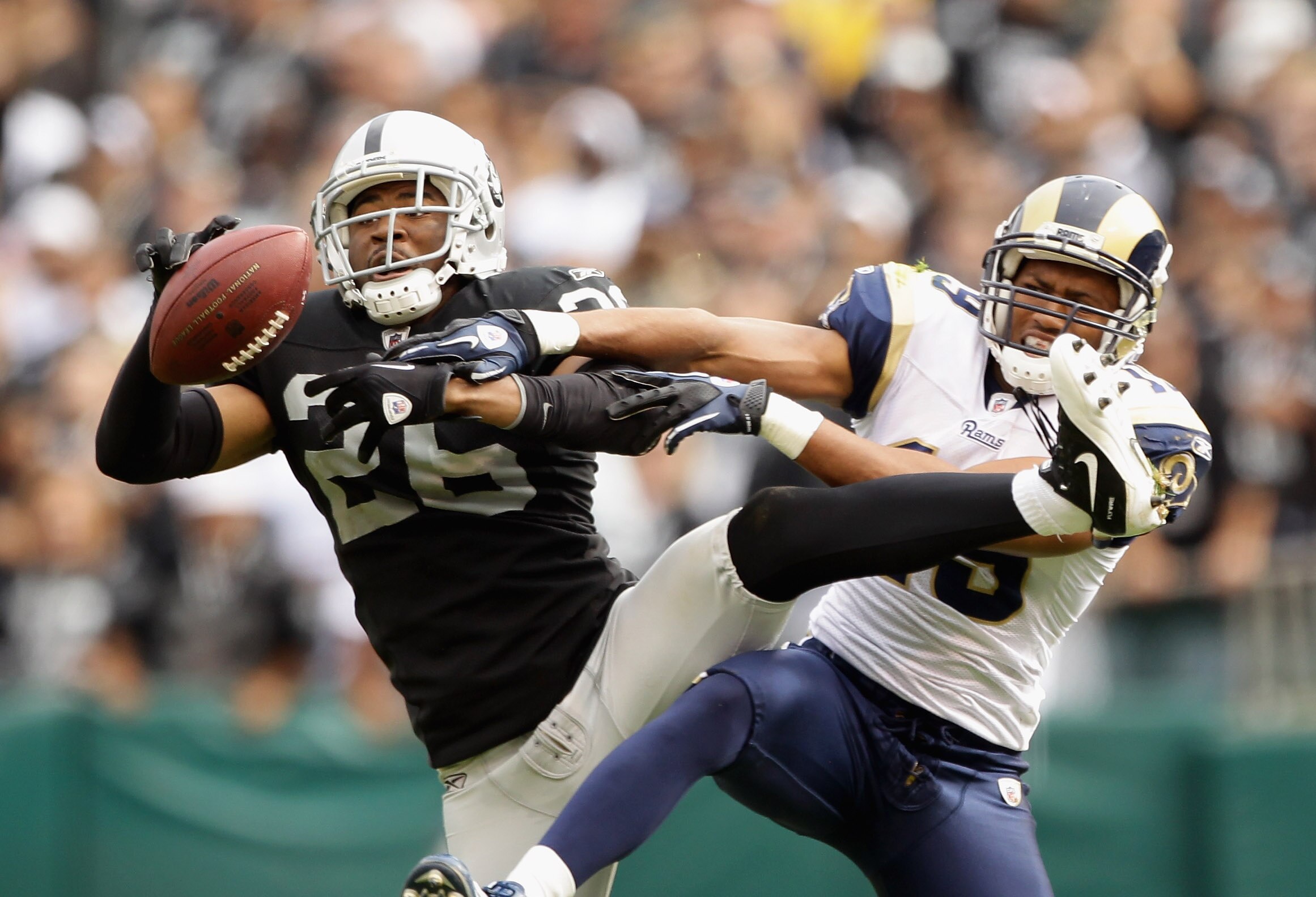 OAKLAND, CA - SEPTEMBER 19:  Stanford Routt #26 of the Oakland Raiders intercepts a pass intended for Laurent Robinson #19 of the St. Louis Rams at the Oakland-Alameda County Coliseum on September 19, 2010 in Oakland, California.  (Photo by Ezra Shaw/Gett