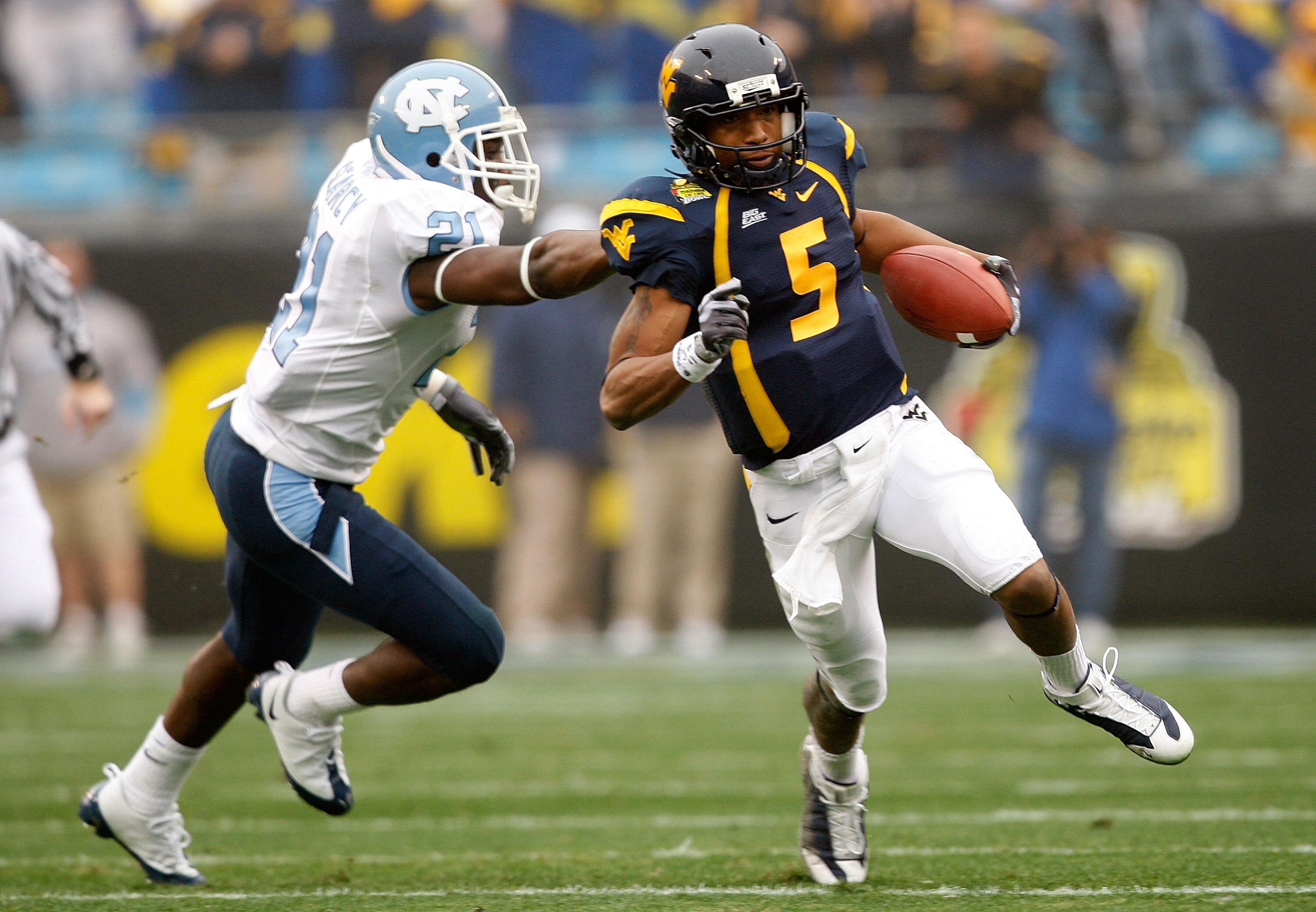 CHARLOTTE, NC - DECEMBER 27:  Da'Norris Searcy #21 of the North Carolina Tar Heels grabs Pat White #5 of the West Virginia Mountaineers during the Meineke Car Care Bowl on December 27, 2008 at Bank of America Stadium in Charlotte, North Carolina.  (Photo