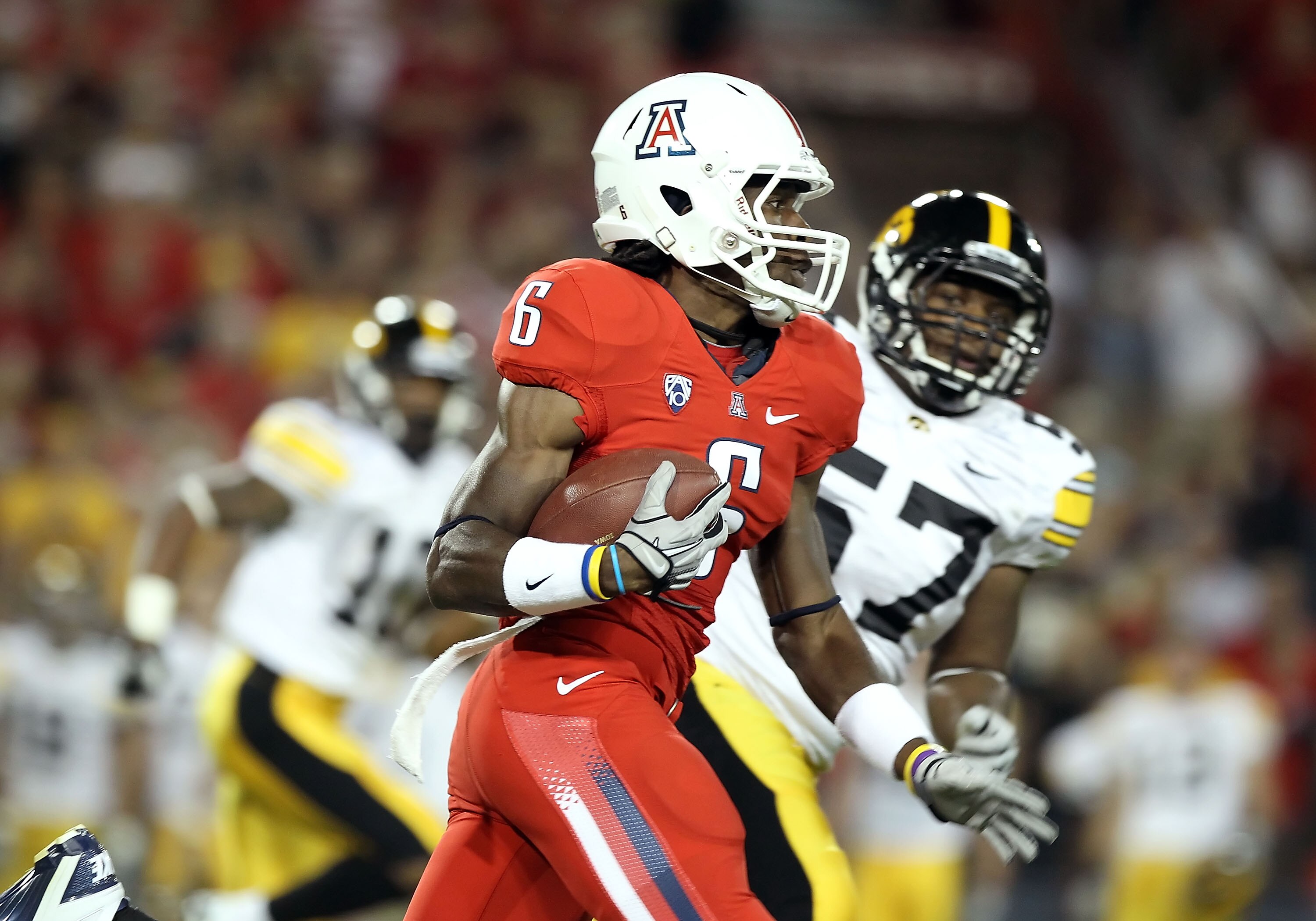 TUCSON, AZ - SEPTEMBER 18:  Wide receiver Travis Cobb #6 of the Arizona Wildcats returns a kick off for a 100 yard touchdown against the Iowa Hawkeyes during the second quarter of the college football game at Arizona Stadium on September 18, 2010 in Tucso