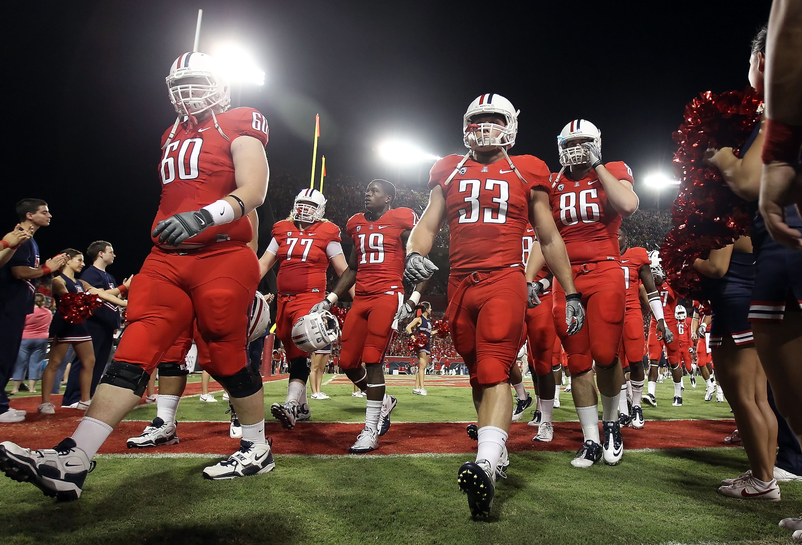 TUCSON, AZ - SEPTEMBER 18:  (L-R) Carter Lees #60, Jake Fischer #33 and Jack Baucus #86 of the Arizona Wildcats walk off the field after warm ups to the college football game against the Iowa Hawkeyes at Arizona Stadium on September 18, 2010 in Tucson, Ar