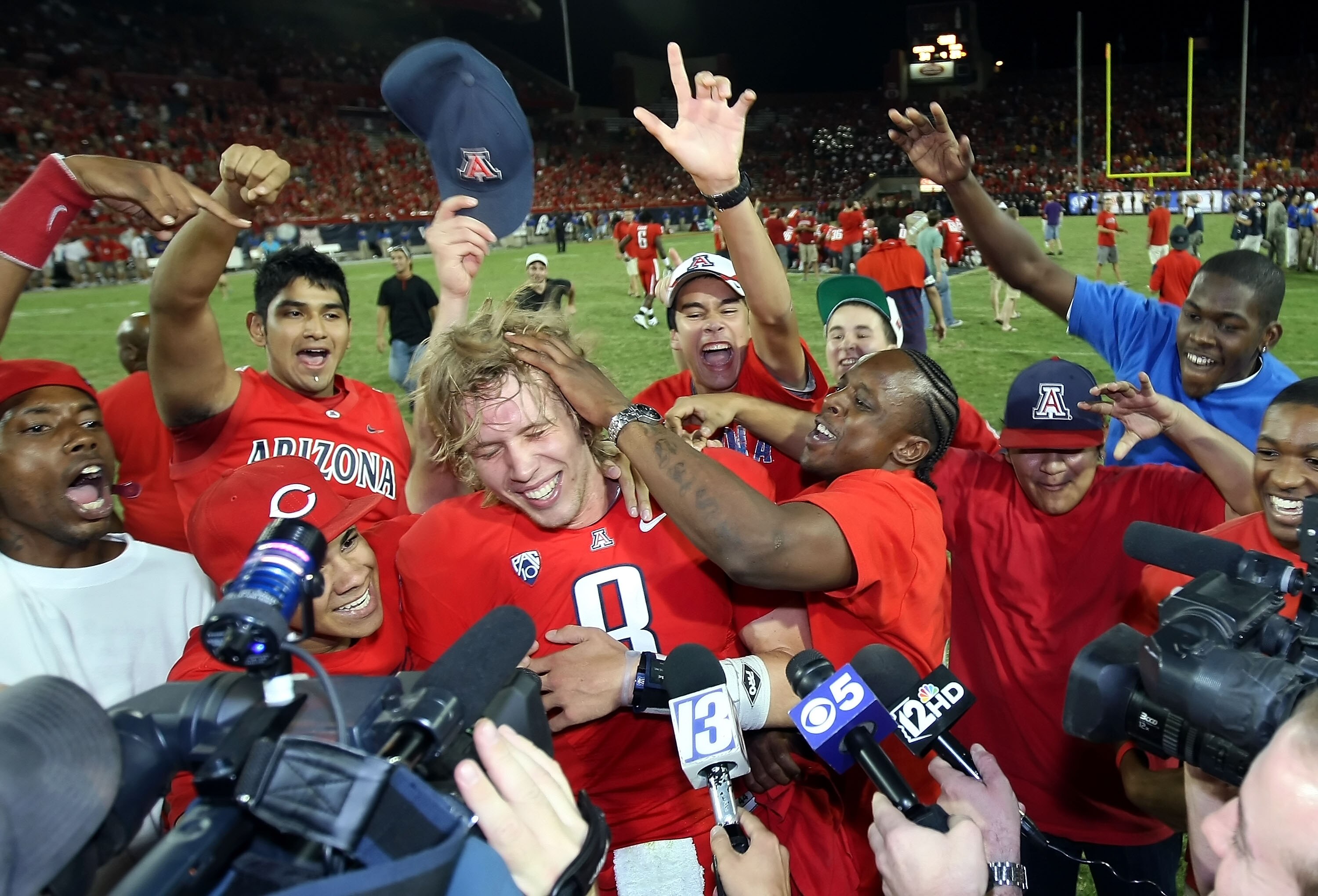 TUCSON, AZ - SEPTEMBER 18:  Quarterback Nick Foles #8 of the Arizona Wildcats celebrates with fans and players after defeating the Iowa Hawkeyes in the college football game at Arizona Stadium on September 18, 2010 in Tucson, Arizona. The Wildcats defeate
