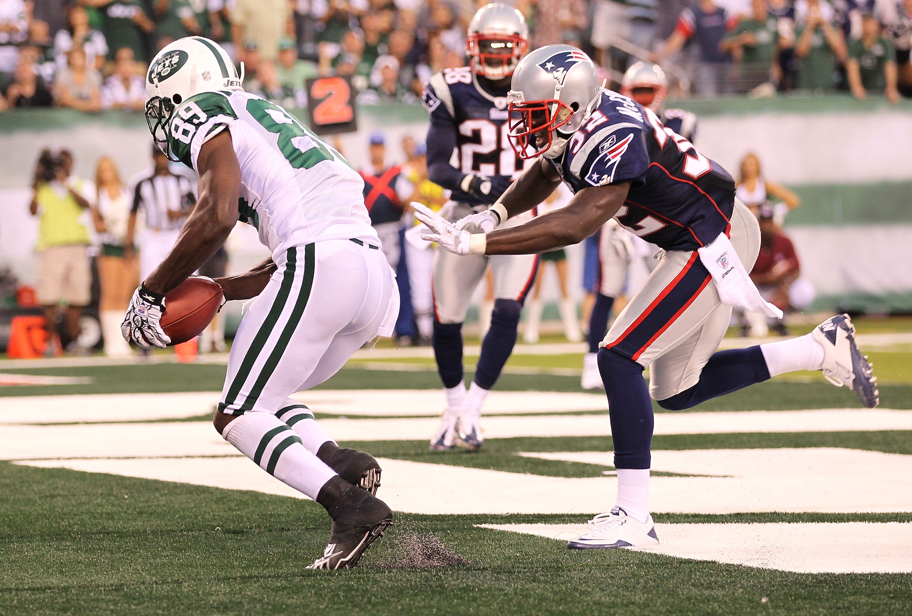 EAST RUTHERFORD, NJ - SEPTEMBER 19:  Jerricho Cotchery #89 of the New York Jetsscores a touchdown against Devin McCourty #32 of the New England Patriots during their  game on September 19, 2010 at the New Meadowlands Stadium  in East Rutherford, New Jerse