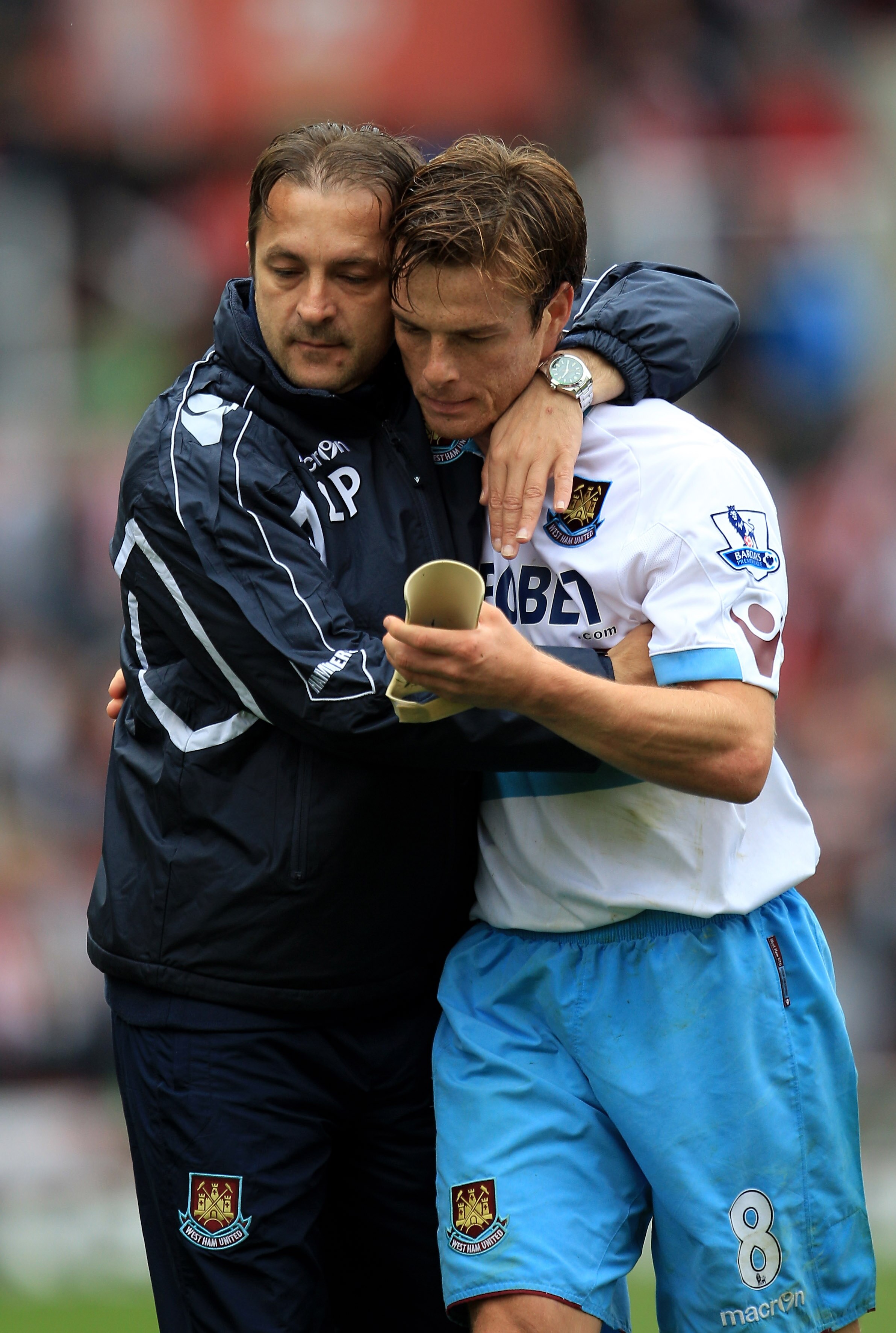 STOKE ON TRENT, ENGLAND - SEPTEMBER 18:  Zeljko Petrovic the assistant manager of West Ham hugs his player Scott Parker during the Barclays Premier League match between Stoke City and West Ham United at the Britannia Stadium on September 18, 2010 in Stoke