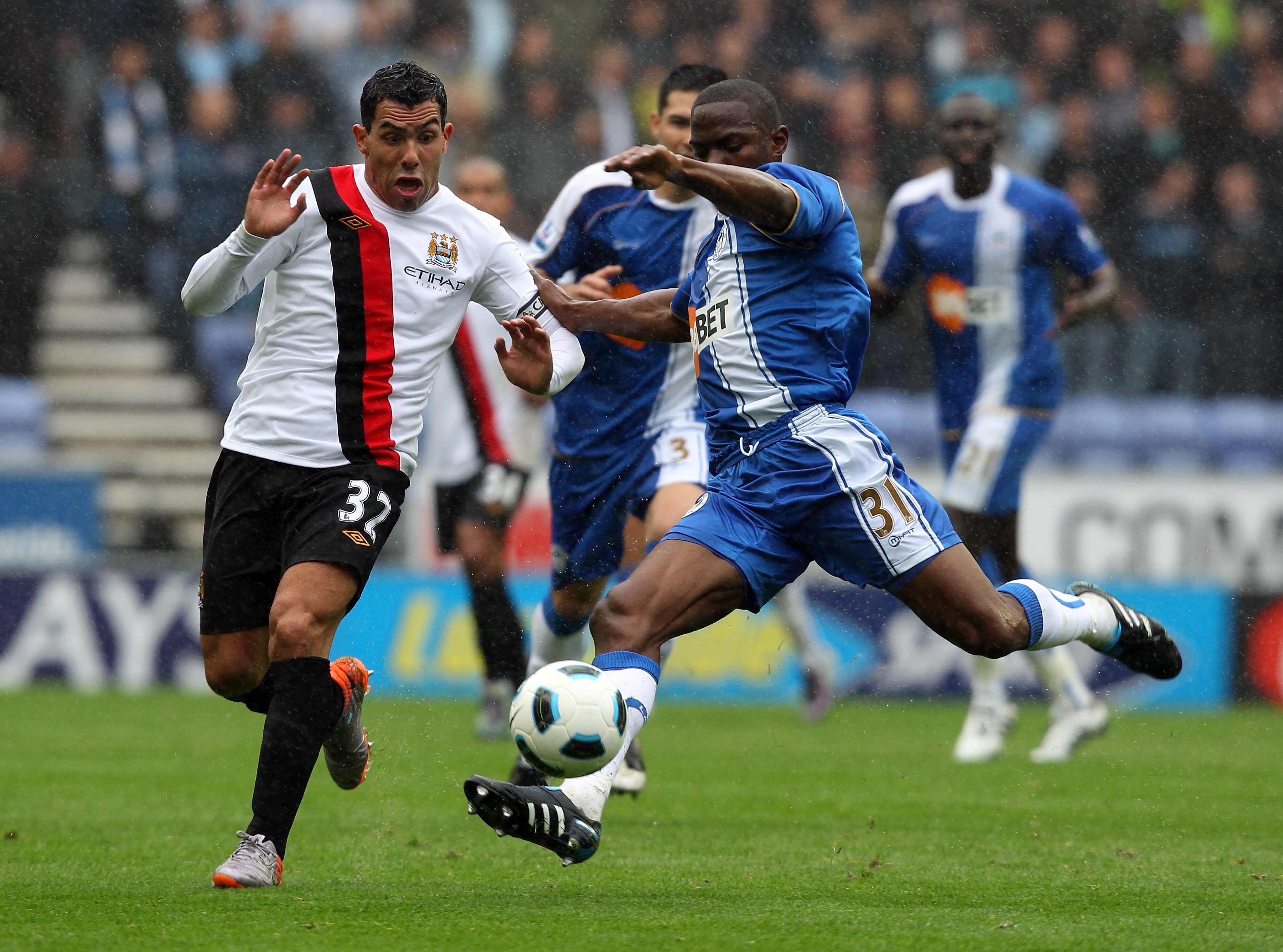WIGAN, ENGLAND - SEPTEMBER 19:  Carlos Tevez of Manchester is challenged by Maynor Figueroa of Wigan during the Barclays Premiership match between Wigan Athletic and Manchester City at the DW Stadium on September 19, 2010 in Wigan, England.  (Photo by Ros