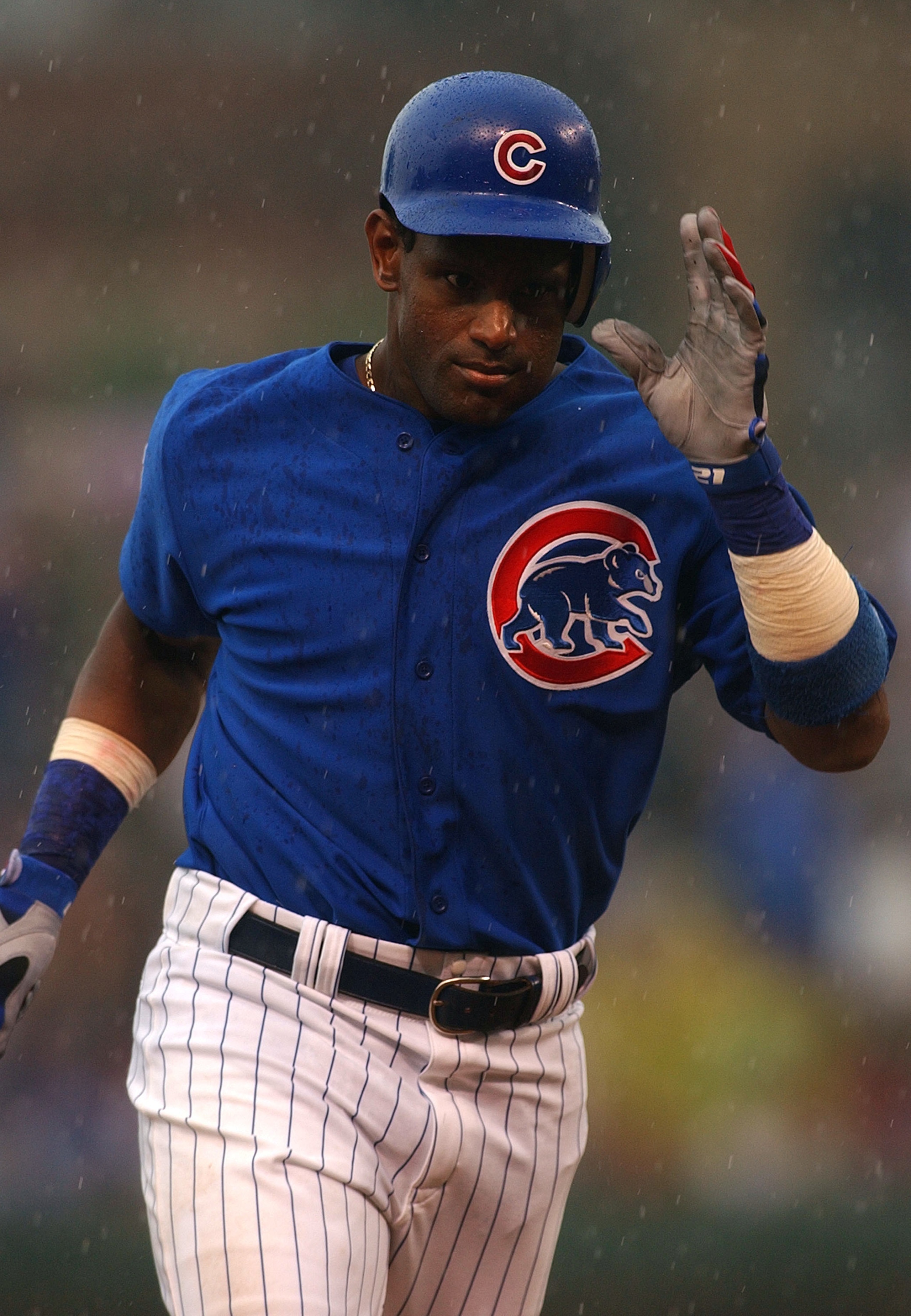 CHICAGO - JULY 21:  Sammy Sosa #21 of the Chicago Cubs runs the bases in the rain after hitting what proved to be the game-winning solo home run in the seventh inning against the Cincinnati Reds July 21, 2004 at Wrigley Field in Chicago, Illinois. The Cub