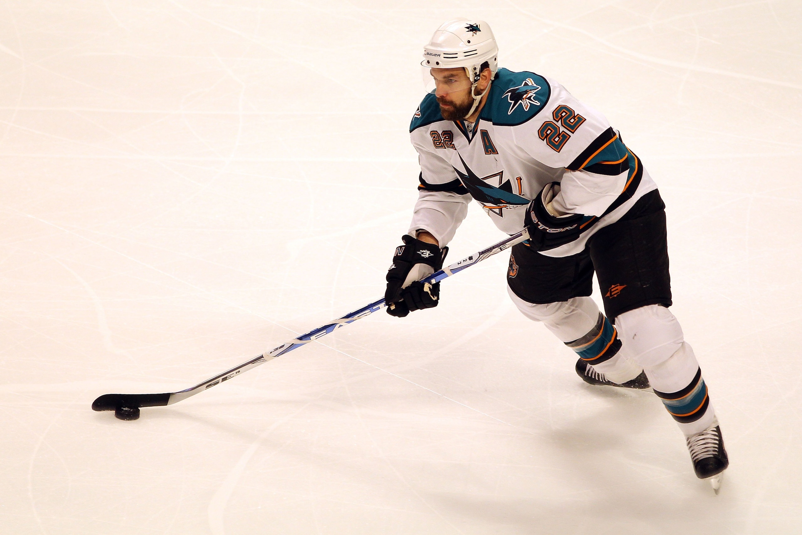 CHICAGO - MAY 23:  Dan Boyle #22 of the San Jose Sharks moves the puck while taking on the Chicago Blackhawks in Game Four of the Western Conference Finals during the 2010 NHL Stanley Cup Playoffs at the United Center on May 23, 2010 in Chicago, Illinois.