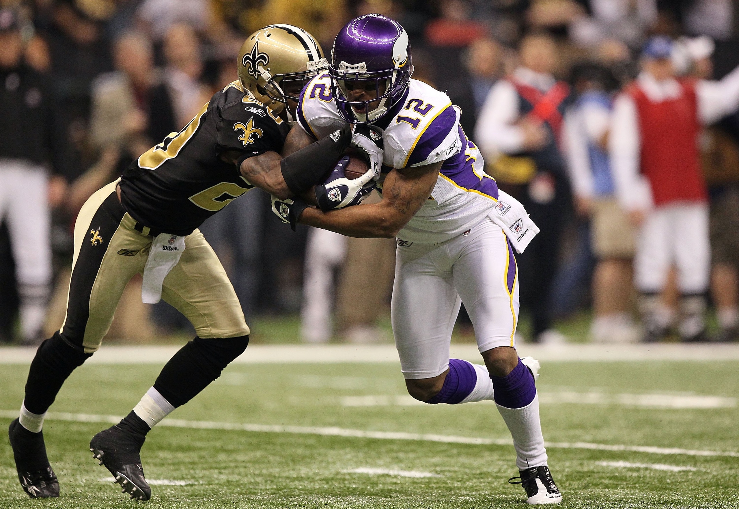 NEW ORLEANS - JANUARY 24:  Percy Harvin #12 of the Minnesota Vikings returns a punt against Randall Gay #20 of the New Orleans Saints during the NFC Championship Game at the Louisiana Superdome on January 24, 2010 in New Orleans, Louisiana. The Saints won