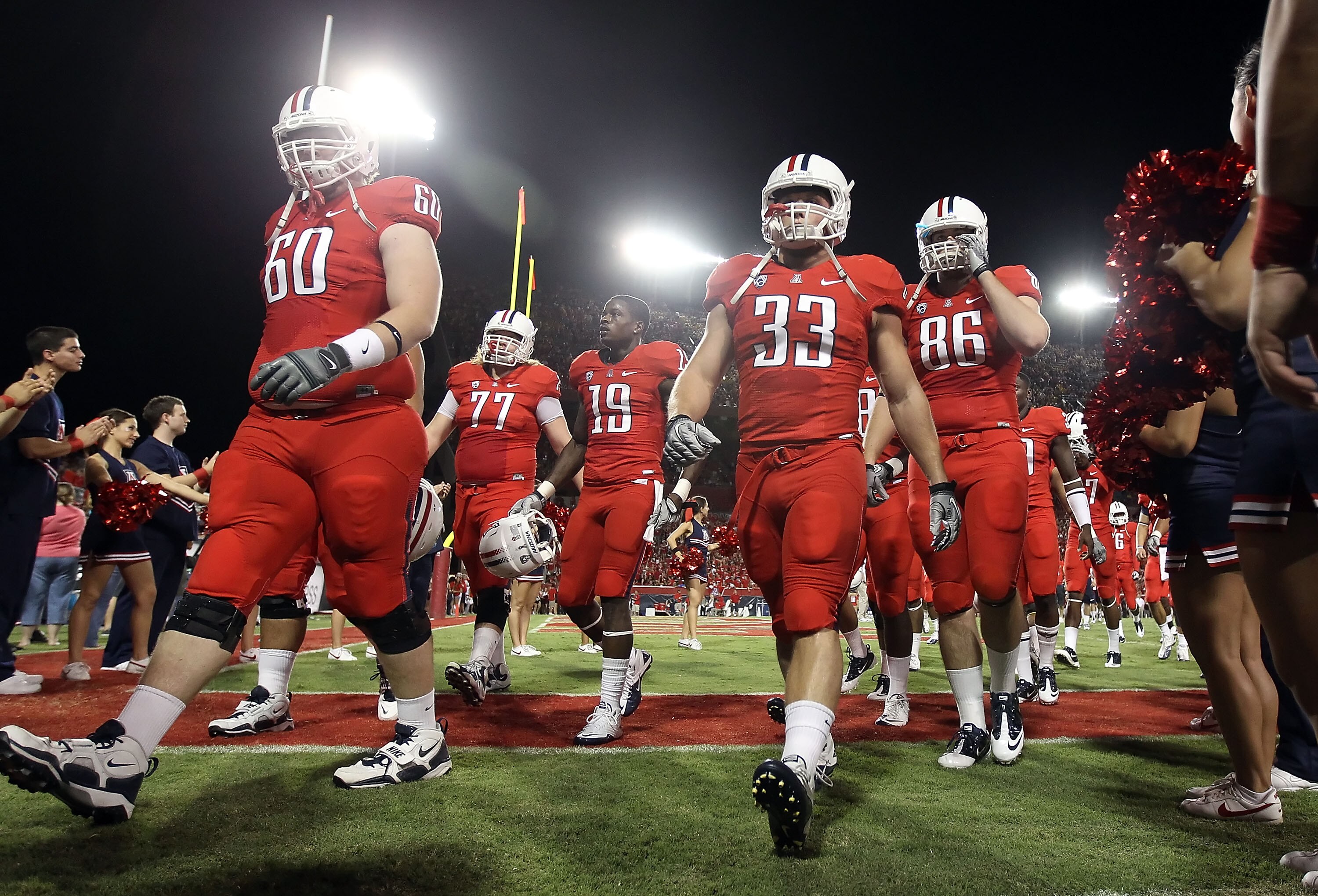 TUCSON, AZ - SEPTEMBER 18:  (L-R) Carter Lees #60, Jake Fischer #33 and Jack Baucus #86 of the Arizona Wildcats walk off the field after warm ups to the college football game against the Iowa Hawkeyes at Arizona Stadium on September 18, 2010 in Tucson, Ar