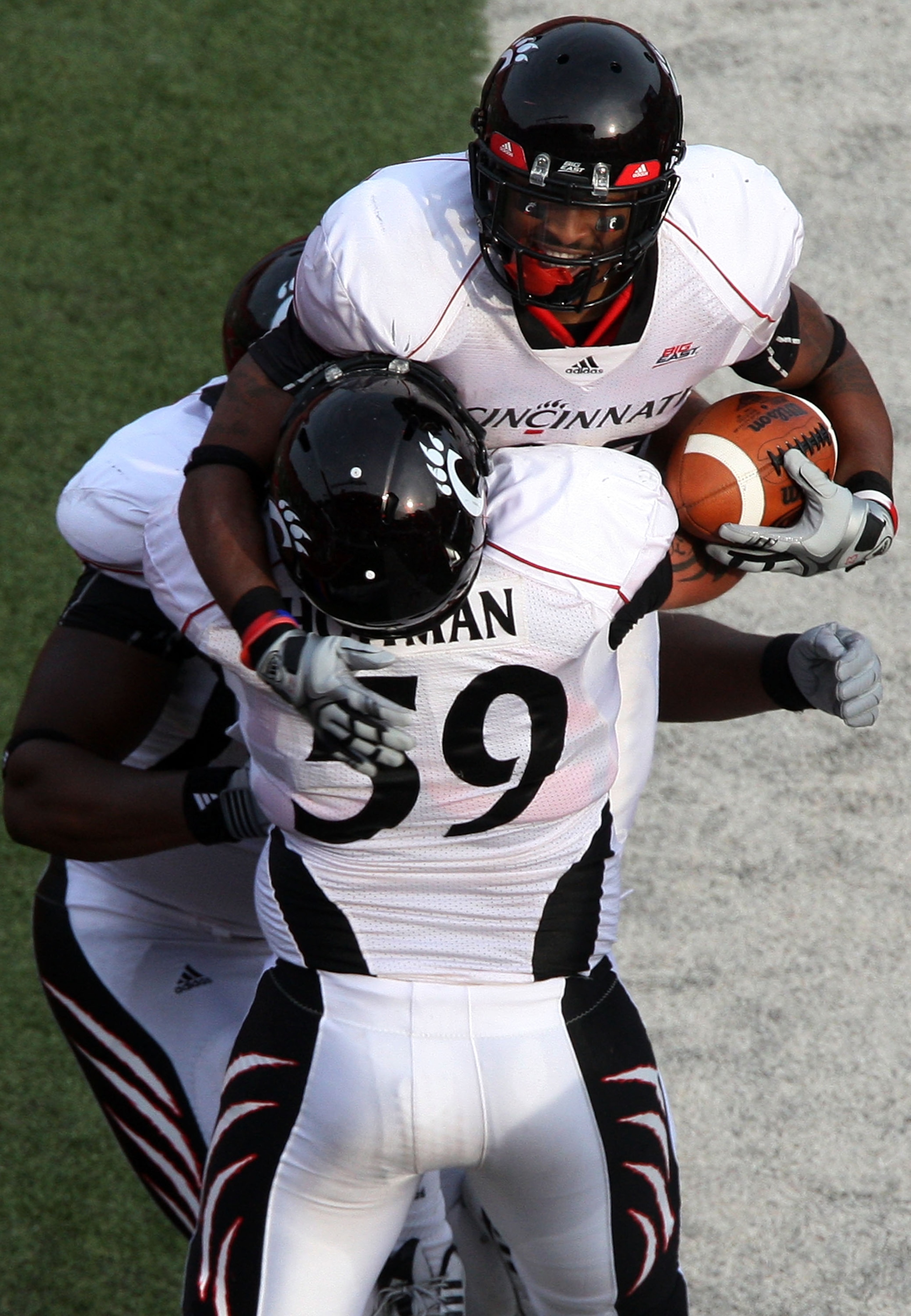 PISCATAWAY, NJ - SEPTEMBER 07:  Isaiah  Pead #23 of the Cincinnati Bearcats celebrates a touchdown against the Rutgers Scarlet Knights with teammate Alex Hoffman #59 at Rutgers Stadium on September 7, 2009 in Piscataway, New Jersey.  (Photo by Jim McIsaac