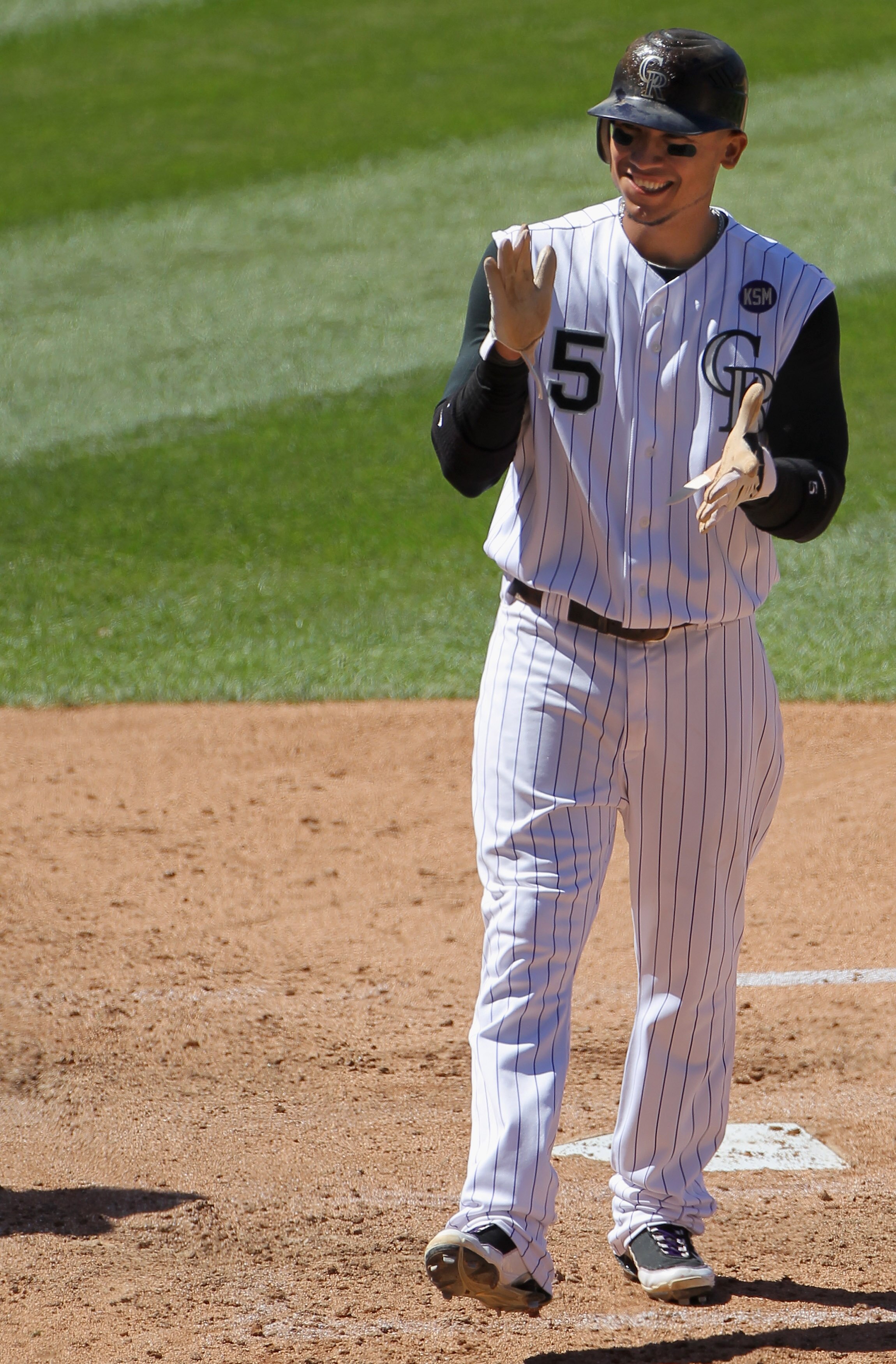 DENVER - SEPTEMBER 06:  Carlos Gonzalez #5 of the Colorado Rockies celebrates as he scores in the third inning against the Cincinnati Reds at Coors Field on September 6, 2010 in Denver, Colorado. The Rockies defeated the Reds 10-5.  (Photo by Doug Pensing