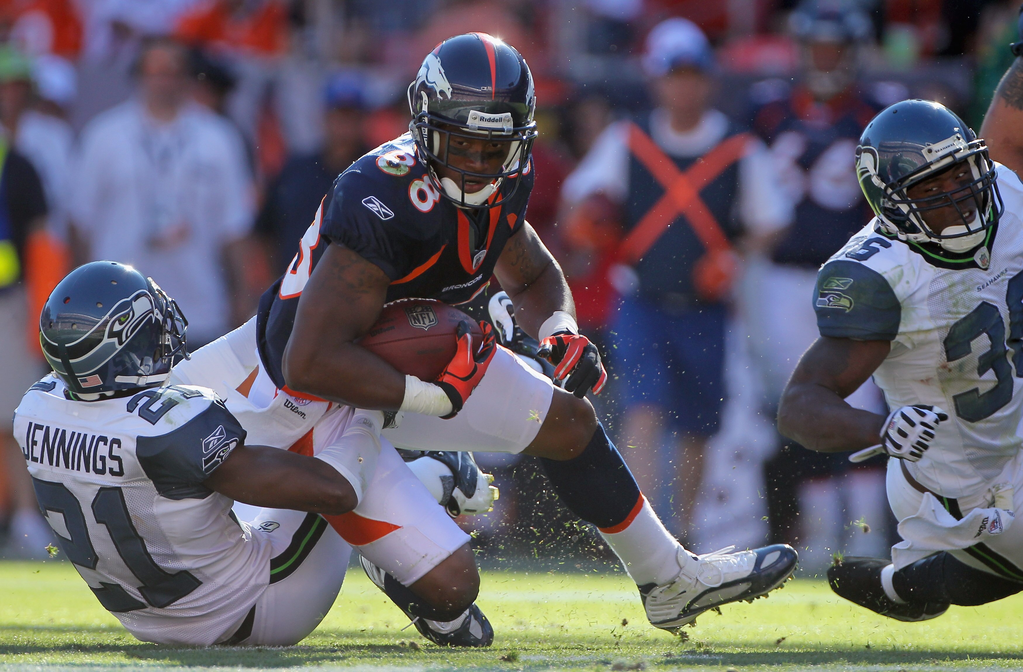 DENVER - SEPTEMBER 19:  Tightend Demaryius Thomas #88 of the Denver Broncos makes a reception as cornerback Kelly Jennings #21 of the Seattle Seahawks makes the tackle at INVESCO Field at Mile High on September 19, 2010 in Denver, Colorado. The Broncos de