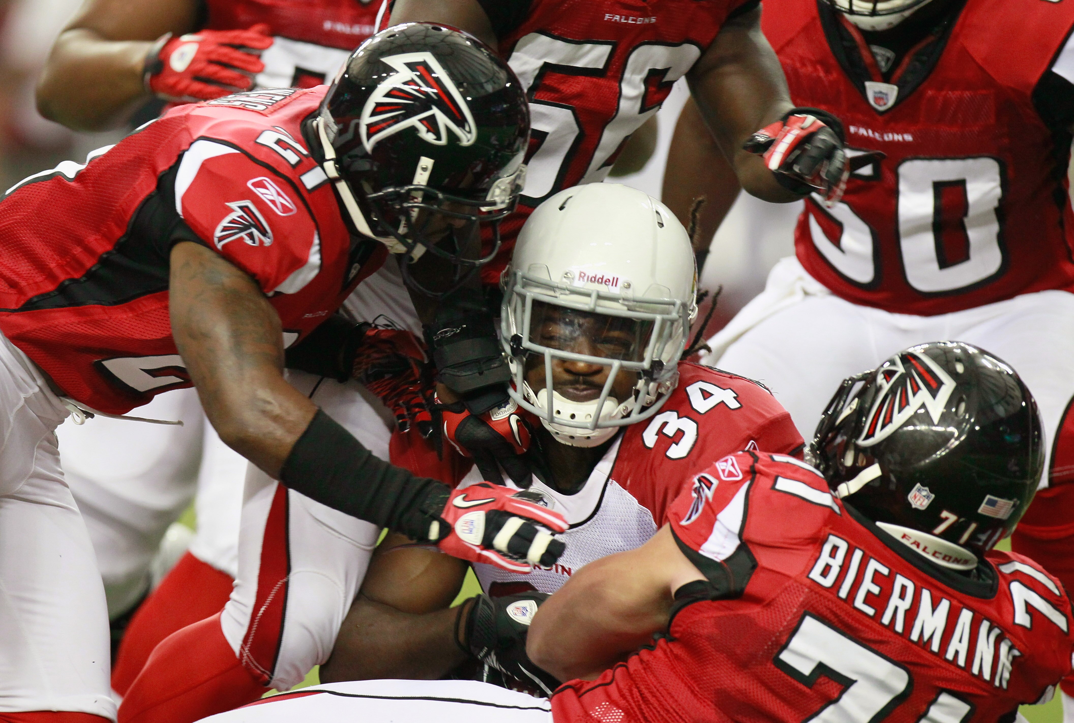 ATLANTA - SEPTEMBER 19:  Tim Hightower #34 of the Arizona Cardinals is tackled by Christopher Owens #21 and Kroy Biermann #71 of the Atlanta Falcons at Georgia Dome on September 19, 2010 in Atlanta, Georgia.  (Photo by Kevin C. Cox/Getty Images)