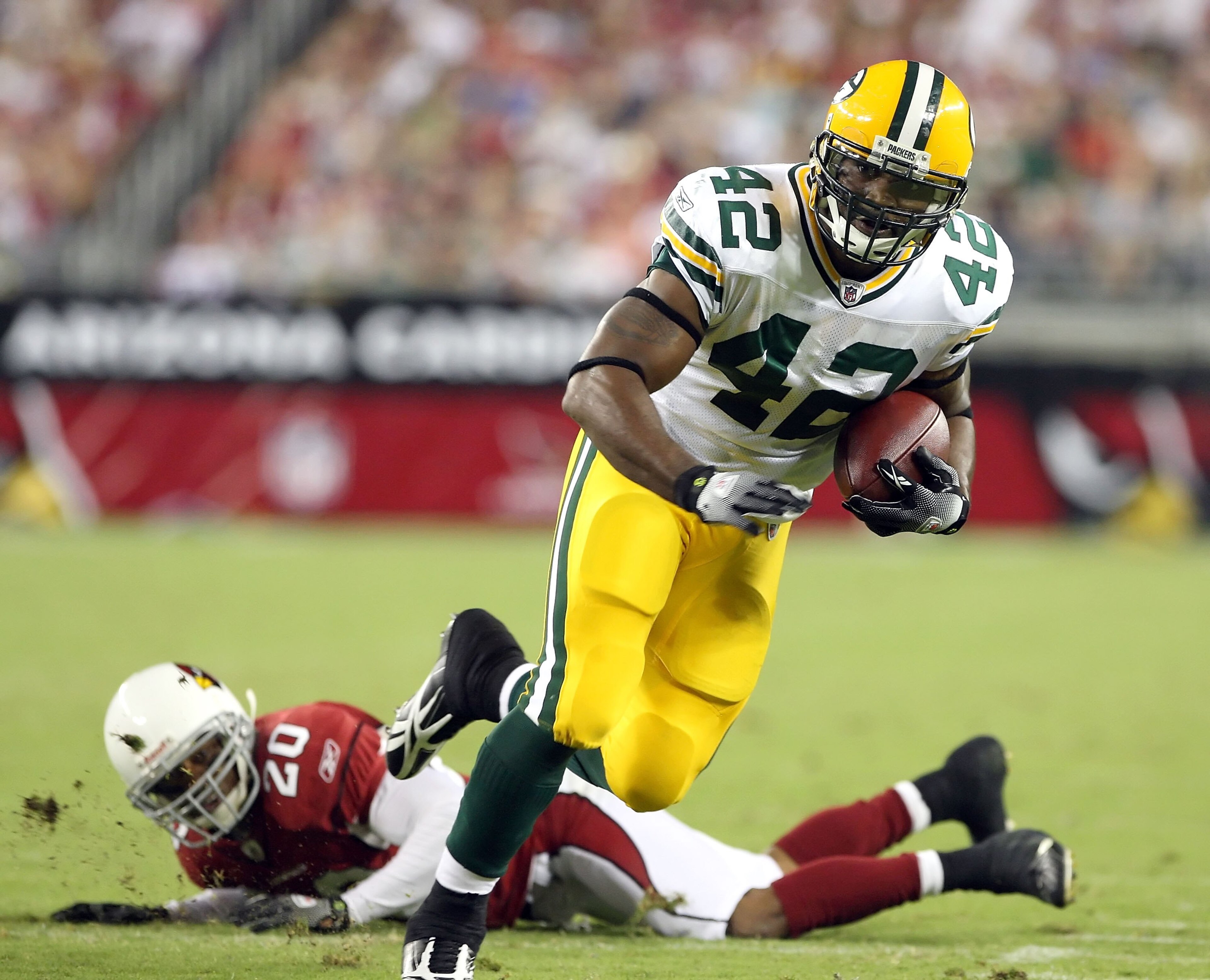 GLENDALE, AZ - AUGUST 28:  Running back DeShawn Wynn #42 of the Green Bay Packers runs with the ball past Ralph Brown #20 of the Arizona Cardinals during the game at the University of Phoenix Stadium on August 28, 2009 in Glendale, Arizona. The Packers de