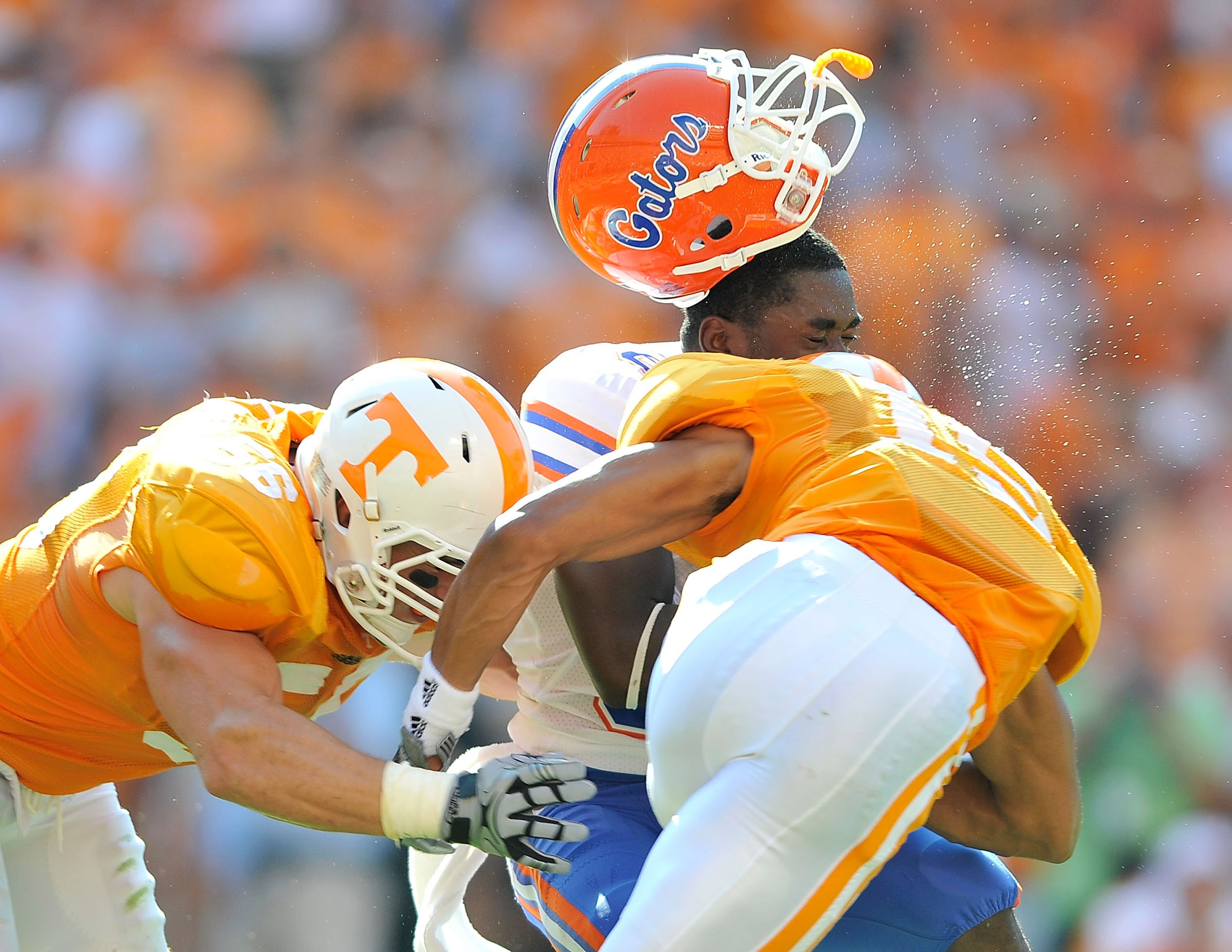 KNOXVILLE, TN - SEPTEMBER 18:  Robert Clark #81 of the Florida Gators loses his helmet after being hit by Jacques Smith #56 and Nick Reveiz #55 of the Tennessee Volunteers during the first half at Neyland Stadium on September 18, 2010 in Knoxville, Tennes