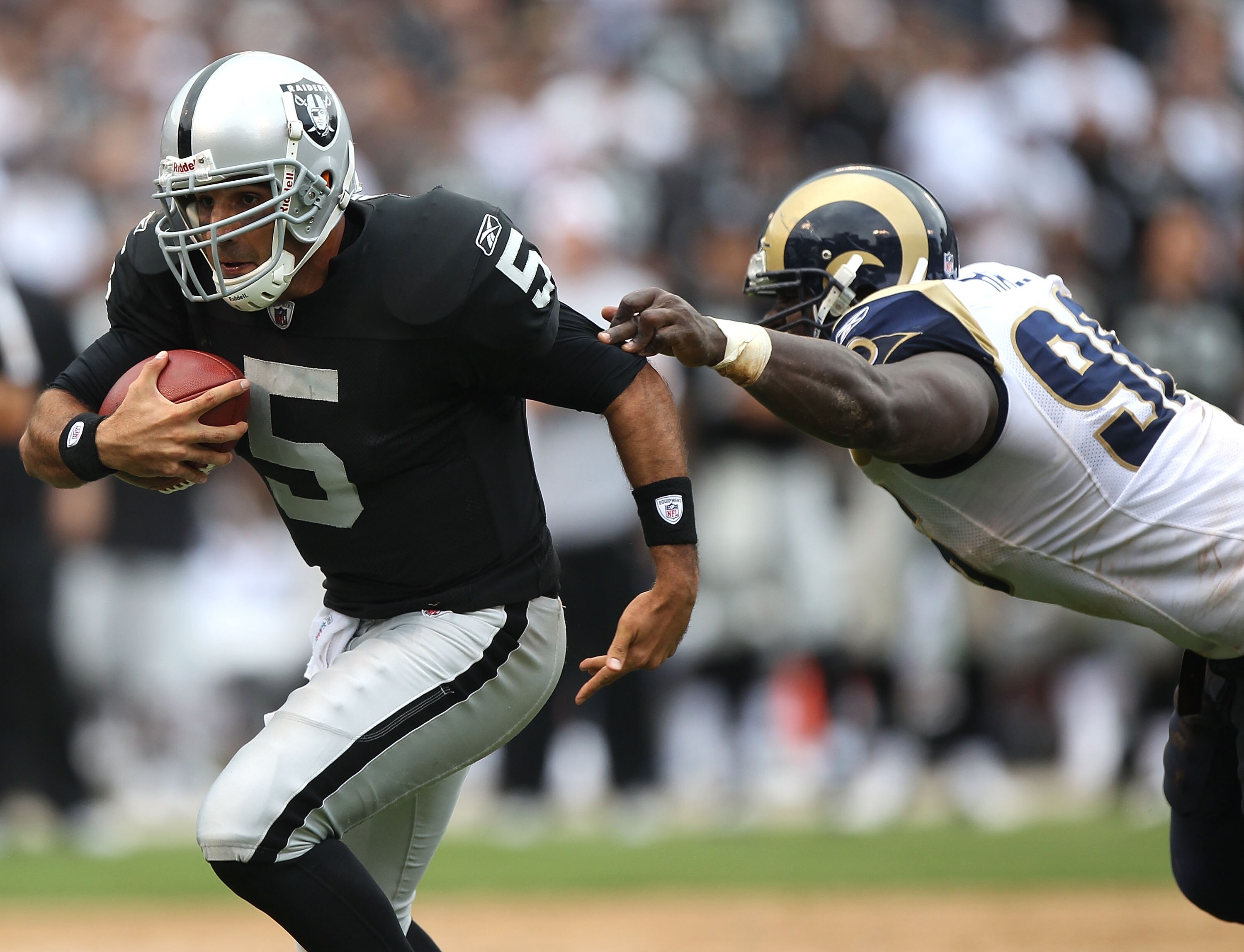 OAKLAND, CA - SEPTEMBER 19:  Bruce Gradkowski #5 of the Oakland Raiders runs against James Hall #96 of the St. Louis Rams during an NFL game at Oakland-Alameda County Coliseum on September 19, 2010 in Oakland, California.  (Photo by Jed Jacobsohn/Getty Im