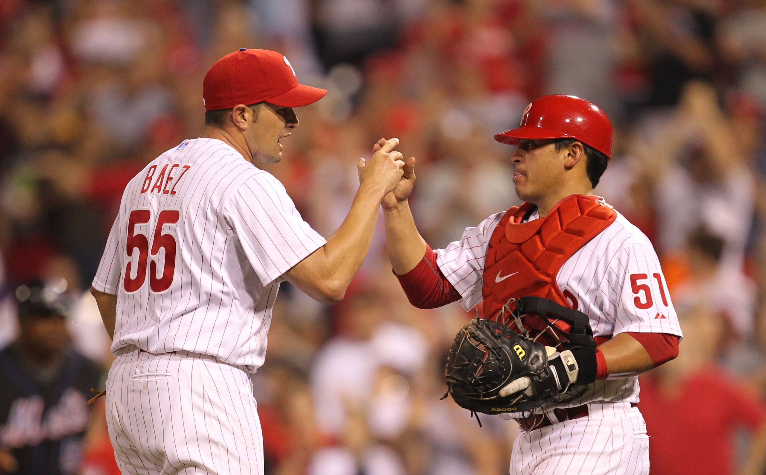 PHILADELPHIA - MAY 2: Relief pitcher Danys Baez #55 of the Philadelphia Phillies is congratulated by catcher Carlos Ruiz #51 after  a game against the New York Mets at Citizens Bank Park on May 2, 2010 in Philadelphia, Pennsylvania. The Phillies won 11-5.