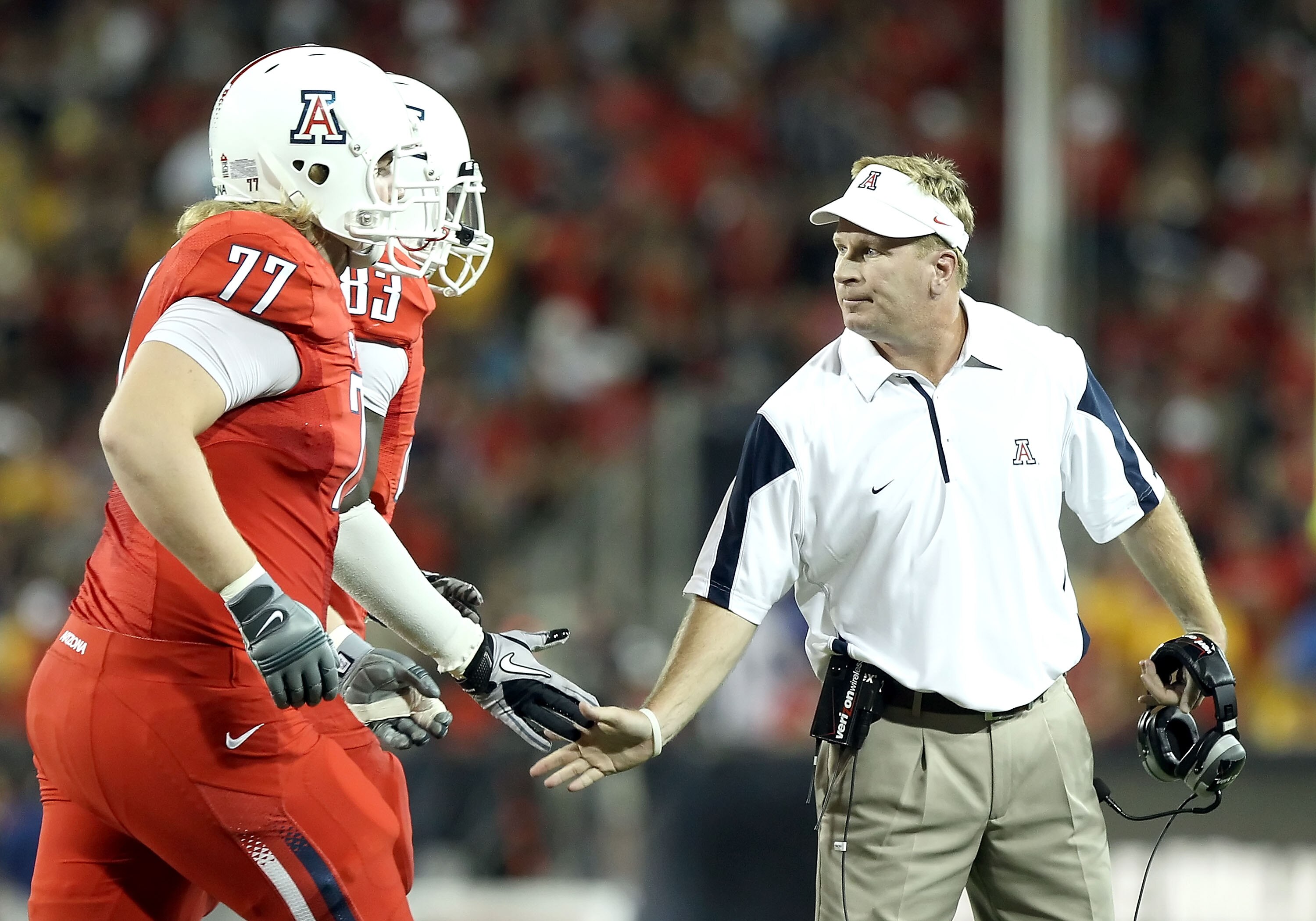 TUCSON, AZ - SEPTEMBER 18:  Head coach Mike Stoops of the Arizona Wildcats high fives teammates after scoring a touchdown during the college football game against the Iowa Hawkeyes at Arizona Stadium on September 18, 2010 in Tucson, Arizona. The Wildcats