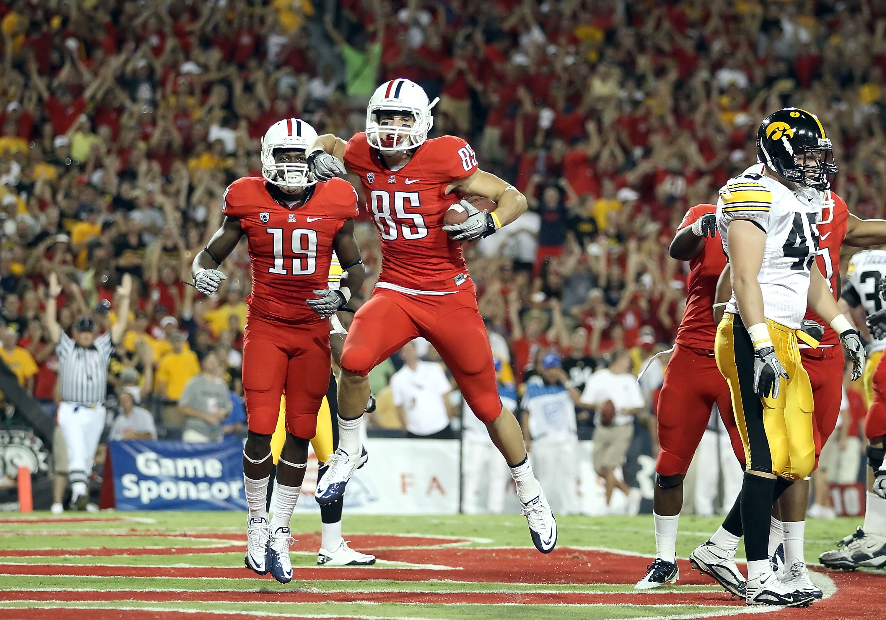 TUCSON, AZ - SEPTEMBER 18:  Wide receiver David Douglas #85 of the Arizona Wildcats celebrates with William Wright #19 after Douglas scored on a 5 yard touchdown reception against the Iowa Hawkeyes during the first quarter of the college football game at