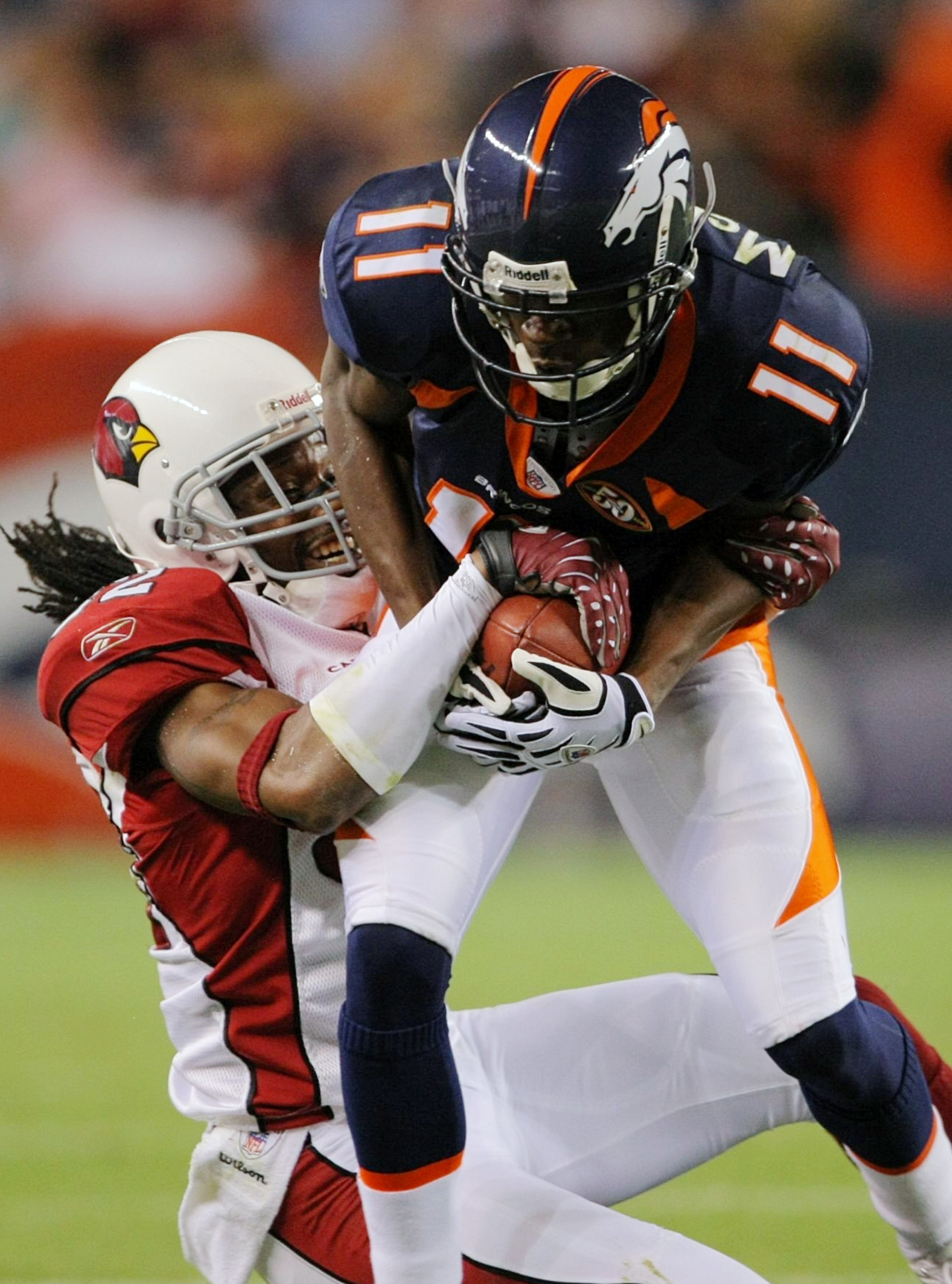 DENVER - SEPTEMBER 3: Wide receiver Kenny McKinley #11 of the Denver Broncos gets tackled by cornerback Greg Toler #32 of the Arizona Cardinals during the NFL preseason game at Invesco Field at Mile High on September 3, 2009 in Denver, Colorado.  (Photo b