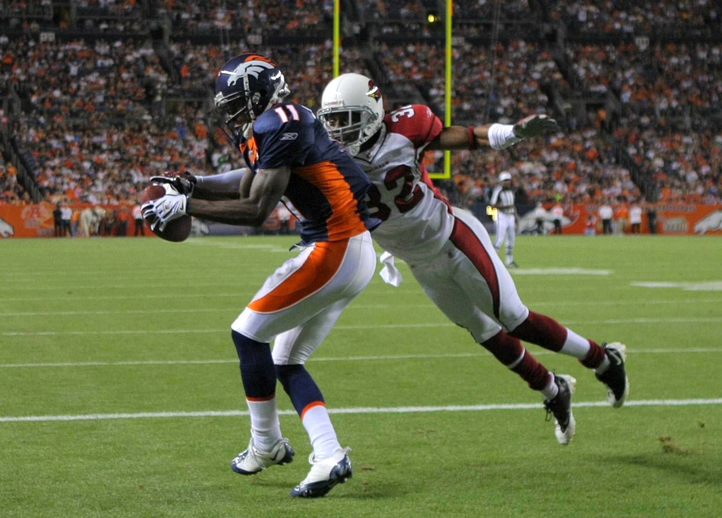 DENVER - SEPTEMBER 3: Kenny McKinley #11 of the Denver Broncos drops a touch down pass in the end zone broken up by cornerback Greg Toler #32 of the Arizona Cardinals during the NFL preseason game at Invesco Field at Mile High on September 3, 2009 in Denv