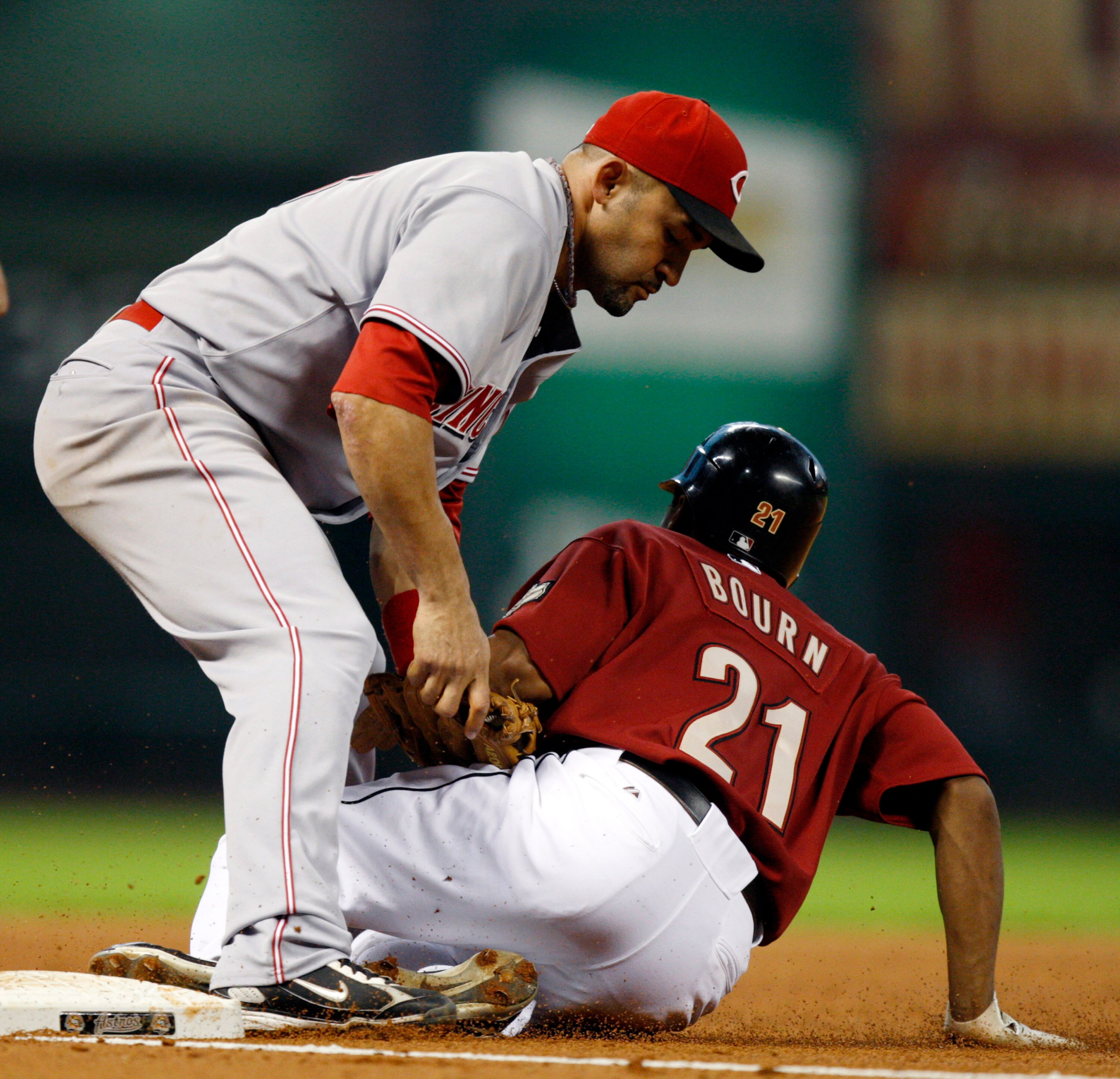 HOUSTON - SEPTEMBER 19:  Michael Bourtn #21 of the Houston Astros is tagged out at third base by Miguel Cairo #43 on a fielders choice against the Cincinnatti Reds at Minute Maid Park on September 19, 2010 in Houston, Texas.  (Photo by Bob Levey/Getty Ima
