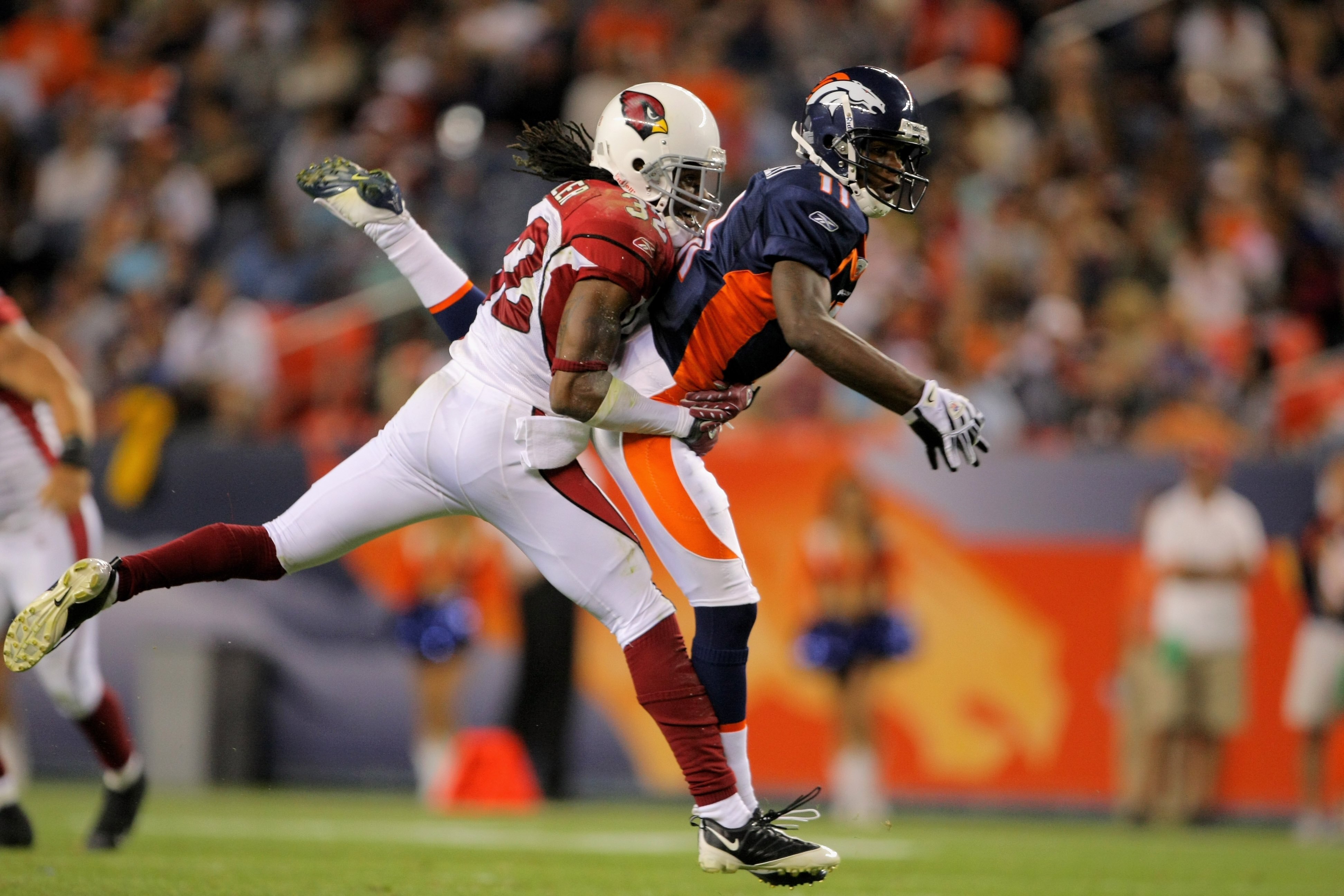 DENVER - SEPTEMBER 03:  Cornerback Greg Toler #32 of the Arizona Cardinals defends against wide receiver Kenny McKinley #11 of the Denver Broncos during preseason NFL action at Invesco Field at Mile High on September 3, 2009 in Denver, Colorado. The Bronc